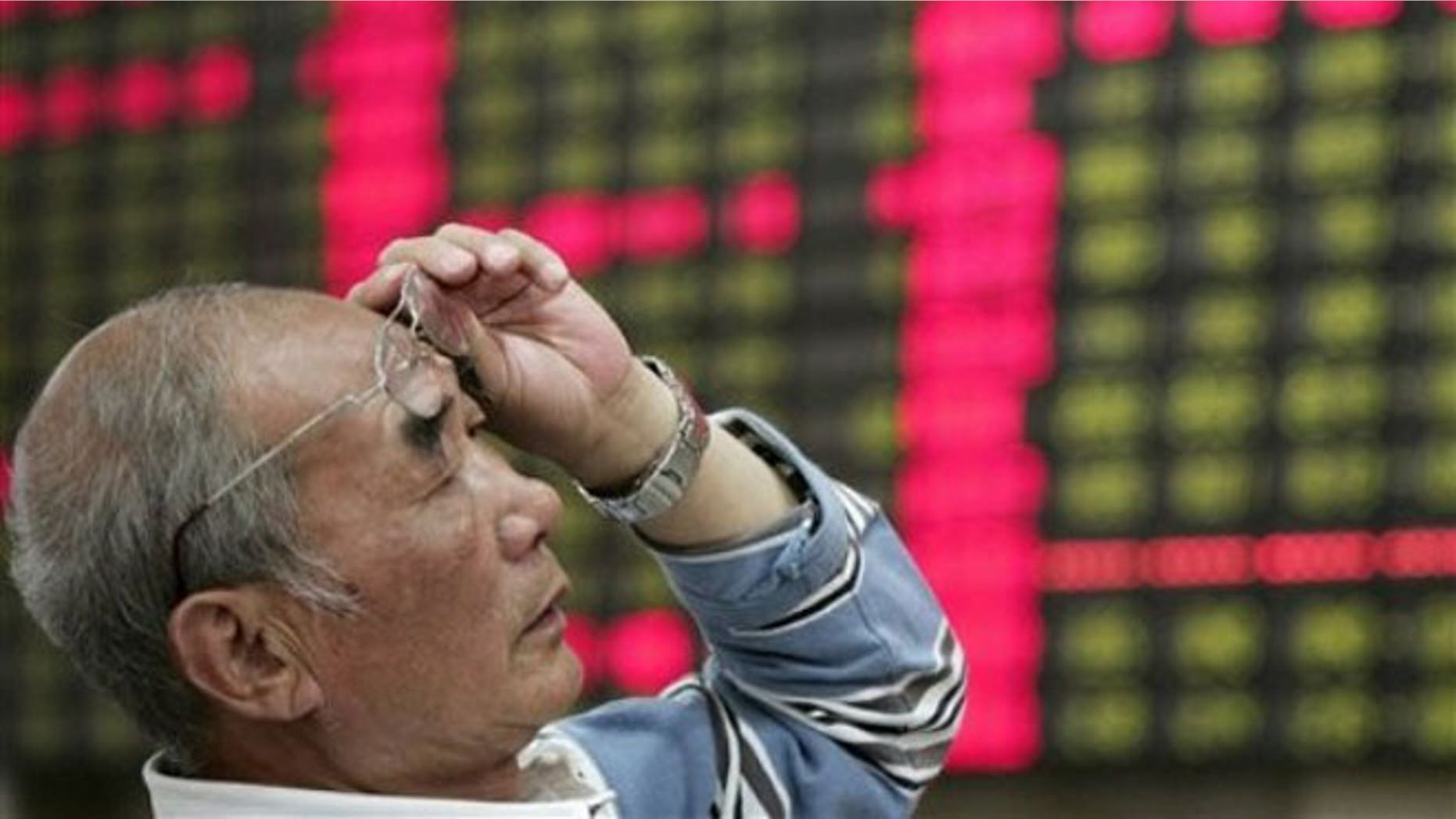 June 4, 2012: An investor looks at the stock price monitor at a private securities company in Shanghai, China.