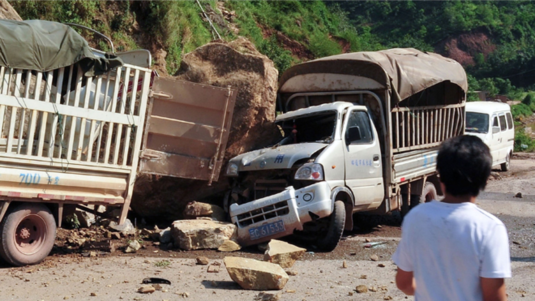 Sept. 7, 2012: A man looks at the trucks damaged by fallen rocks after an earthquake in Zhaotong town, Yiliang County, southwest China's Yunnan Province.