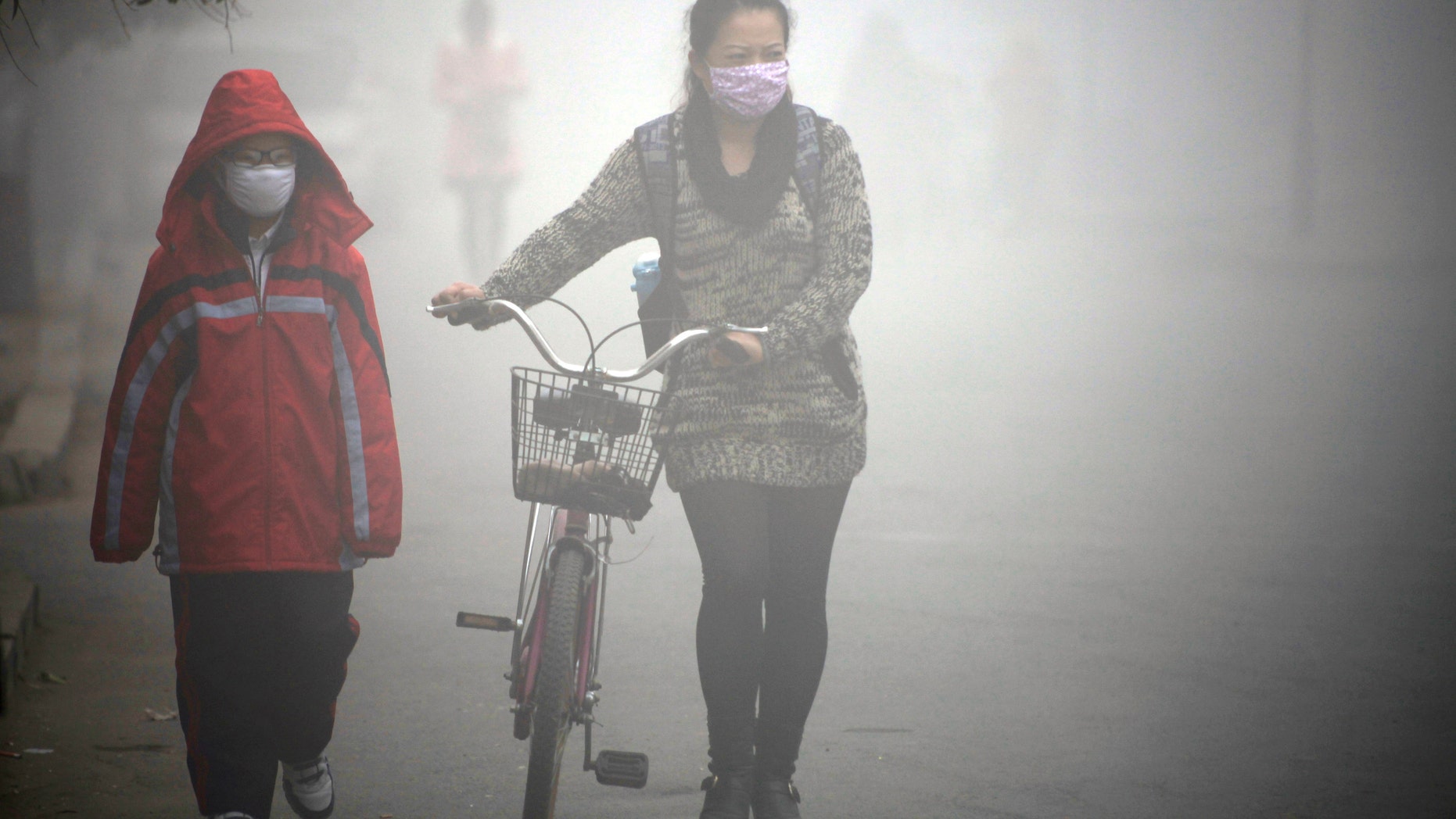 People walk along a street during a smoggy day in Jilin, Jilin province, October 22, 2013. (REUTERS/Stringer)