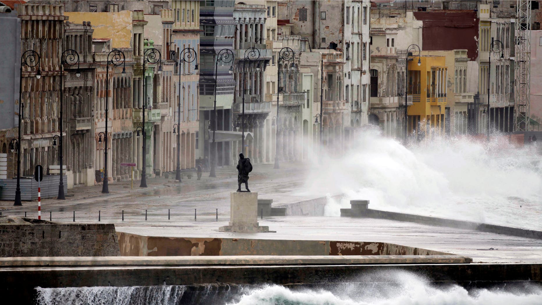 FILE - In this Dec. 13, 2010 file photo, a statue of Venezuelan independence hero Francisco de Miranda stands as waves splash over the sea wall onto Malecon Avenue during heavy winds in Havana, Cuba. Thousands of Cuban-Americans are heading to Havana this holiday season carrying everything from electronics and medicine to clothing and toiletries to help relatives back home supplement monthly salaries averaging about $20. Not only are Cuban-Americans visiting the island in far greater numbers since President Barack Obama lifted travel restrictions last year, they are bringing more stuff. One carrier says the average bag weight per passenger is up 55 percent _ and many Miami-Havana flights are shadowed by a separate cargo plane just to haul the load. (AP Photo/Javier Galeano, File)