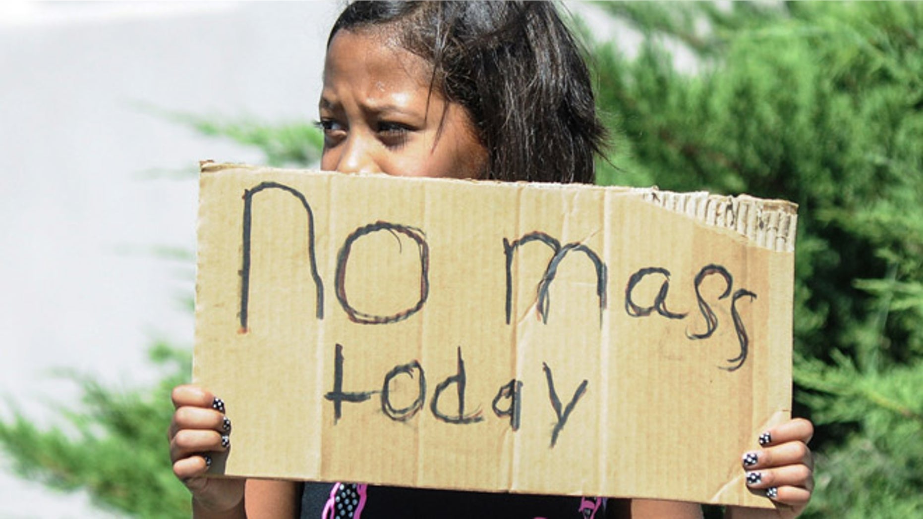 Aaliyah Doninguez, 11, stands on N. Alameda Boulevard on Sunday, Aug. 2, 2015, in Las Cruces, N.M., advising parishioners that Holy Cross Catholic Church mass is canceled. Churchgoers were left shaken during Sunday morning services after authorities say explosions occurred less than 30 minutes apart outside two Las Cruces churches. (Robin Zielinski/The Las Cruces Sun-News via AP) MANDATORY CREDIT