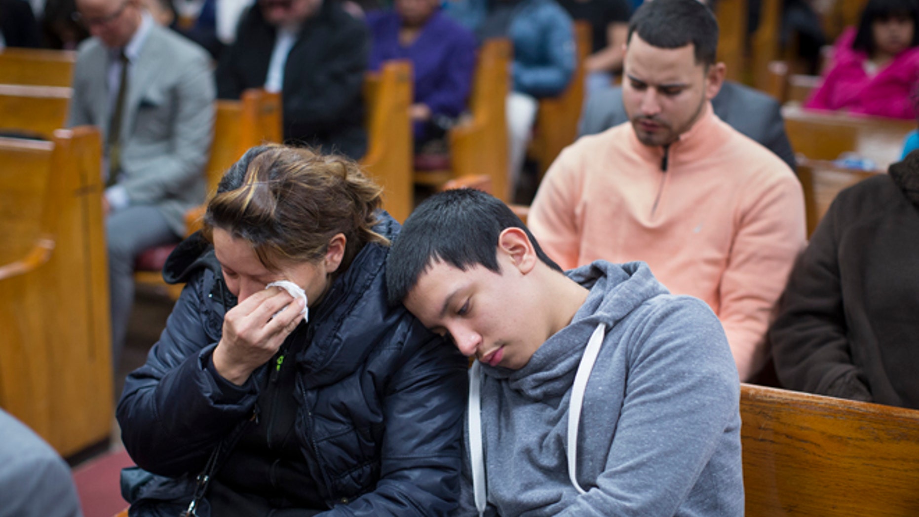 Parishioners mourn during Sunday services at the Church of God of Third Avenue as the congregation welcomed members of the Spanish Christian Church that was destroyed by Wednesday's explosion in the East Harlem neighborhood of New York, Sunday, March 16, 2014. The Spanish Christian Church had been located on the first floor of one of the destroyed buildings. On Saturday a crew at the blast site found a large Bible in the rubble and returned it to the church's pastor. (AP Photo/John Minchillo)