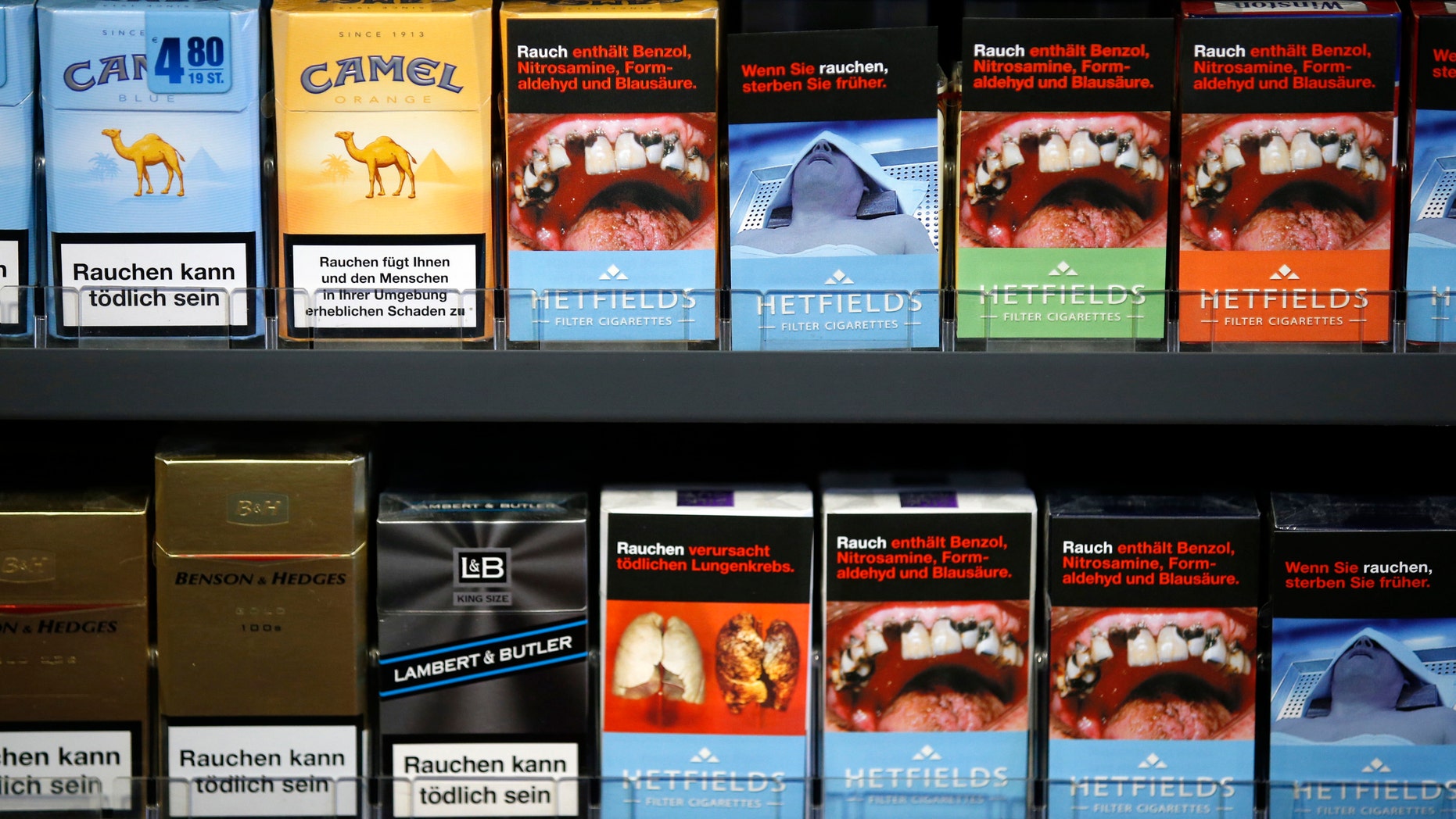 Cigarette boxes with an affixed, self-made cigarette label displaying graphic images and those with the original label are pictured in Berlin February 9, 2013.