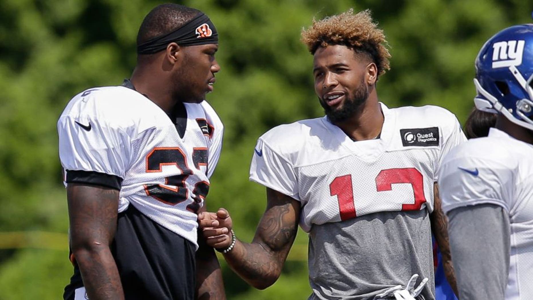Cincinnati Bengals halfback Jeremy Hill, left, and New York Giants wide receiver Odell Beckham Jr. speak on the sidelines during a joint NFL football training camp, Wednesday, Aug. 12, 2015, in Cincinnati. (AP Photo/John Minchillo)