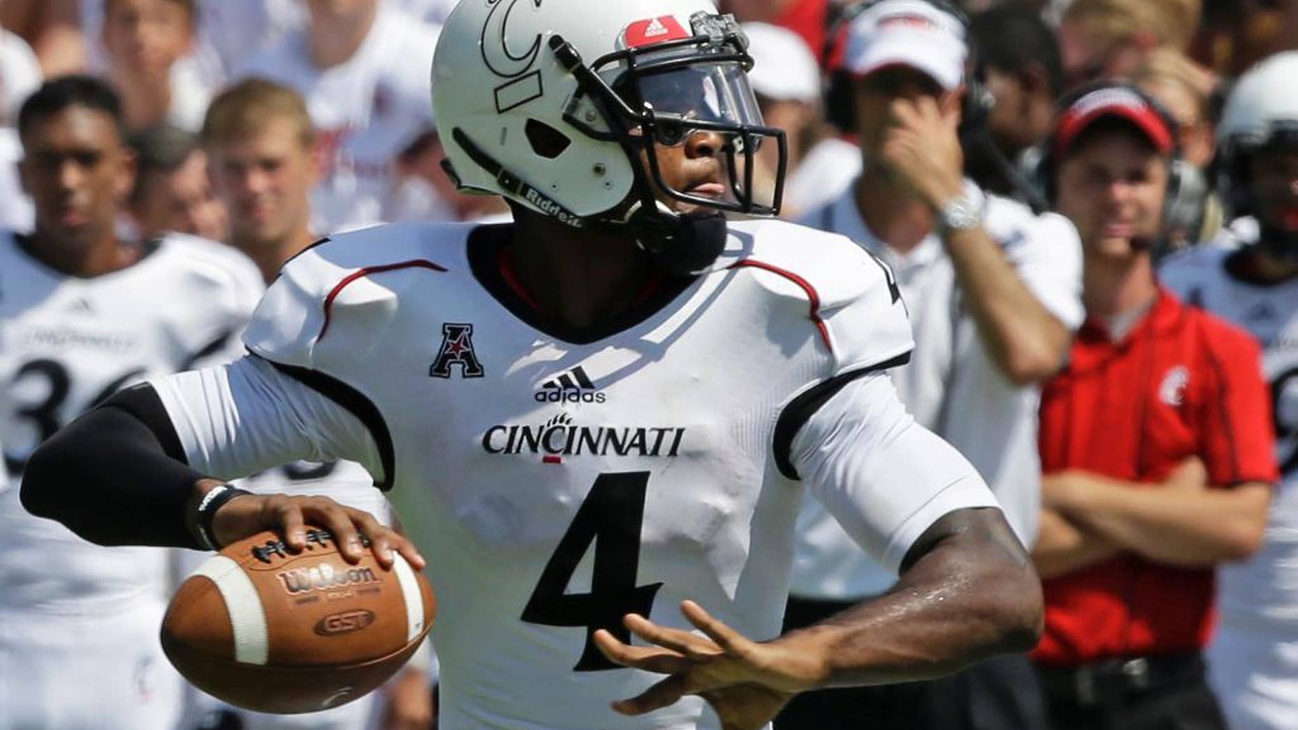 FILE - In this Aug. 31, 2013, file photo, Cincinnati quarterback Munchie Legaux throws a pass in an NCAA college football game in Cincinnati. Legaux received another year of eligibility when he suffered a knee injury in the fall of 2013 and was able to briefly play as a backup in the Bearcats win over Toledo last Friday. (AP Photo/Al Behrman, File)