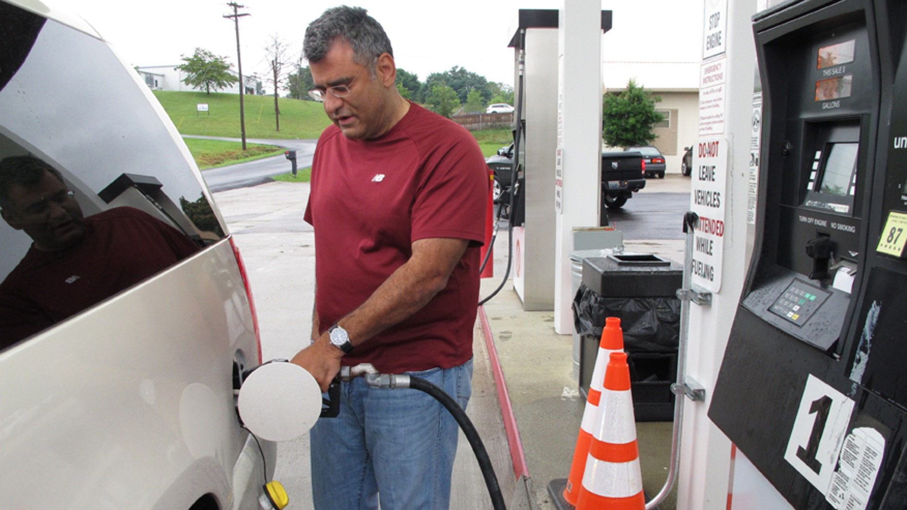Samir Cook fills up his vehicle at a city-run station on Saturday, July 19, 2014, in Somerset, Ky. The station on the outskirts of Somerset opened to the public on Saturday, selling regular unleaded gas for $3.36 a gallon. In the first three hours, about 75 customers fueled up at the no-frills city station, where there are no snacks, no repairs and only regular unleaded gas. The citys mayor says he hopes the no-frills station will lower gas prices around town. (AP Photo/Bruce Schreiner)