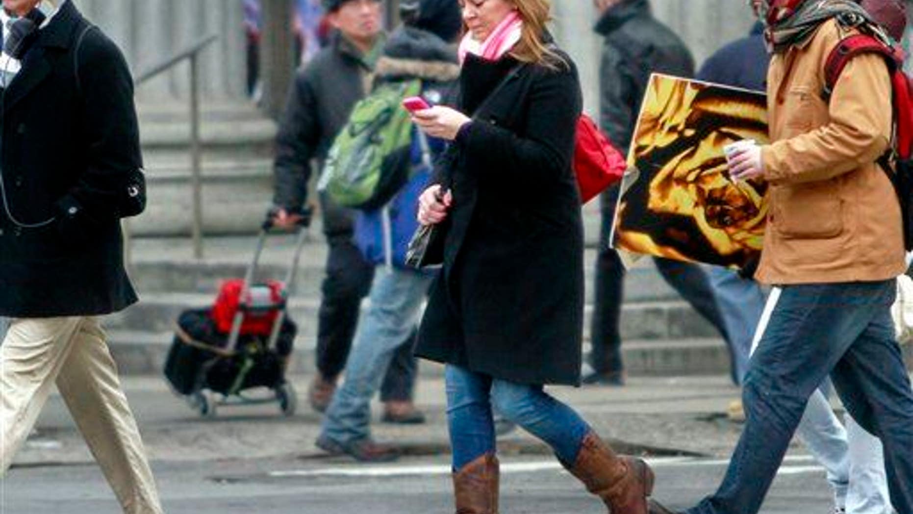 File photo of a pedestrian walking while using a phone in New York.