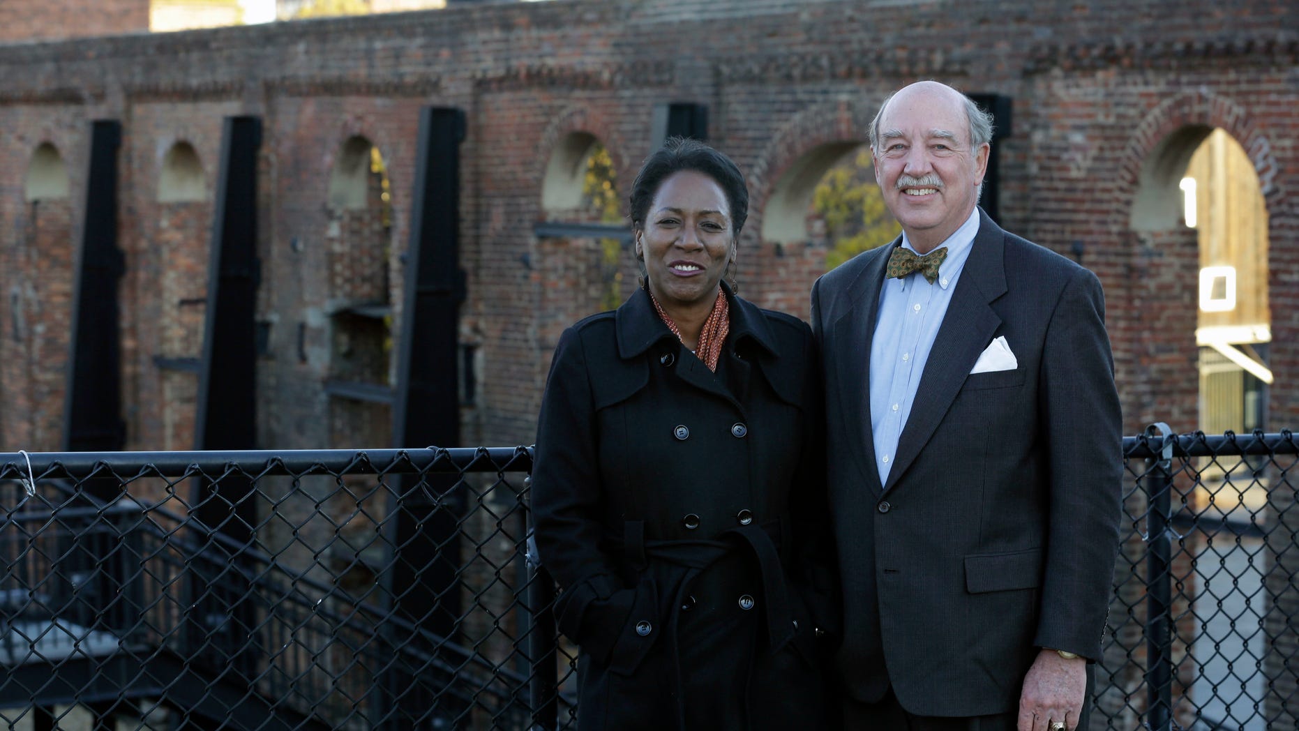 Christy Coleman, left, director of the American Civil War Center at Tredegar Iron Works, left, and Waite Rawls of the Museum of the Confederacy, pose in front of the ruins of the old Tredegar Iron Works in Richmond, Va., Wednesday, Nov. 13, 2013. (AP Photo/Steve Helber)