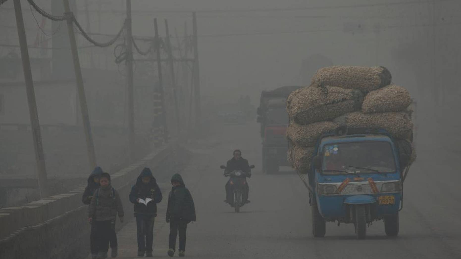 FILE - In this Feb. 26, 2014 file photo, children walk back home after school on a severely polluted day in Shijiazhuang, in northern China's Hebei province. A groundbreaking agreement struck Wednesday, Nov. 12, 2014, by the United States and China puts the world's two worst polluters on a faster track to curbing the heat-trapping gases blamed for global warming. (AP Photo/Alexander F. Yuan, File)