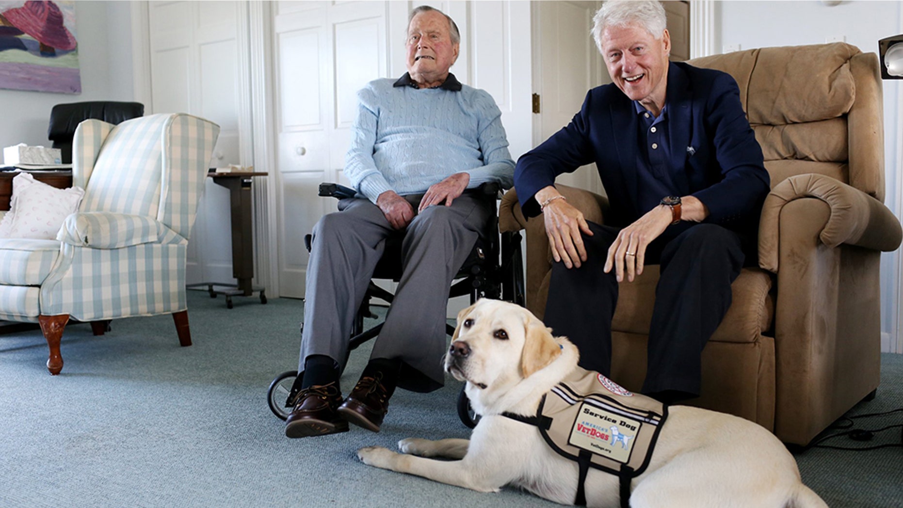 A photo sent via Twitter shows Sully lounging at the feet of Former President George H.W. Bush and former President Bill Clinton, who had been visiting on Monday.