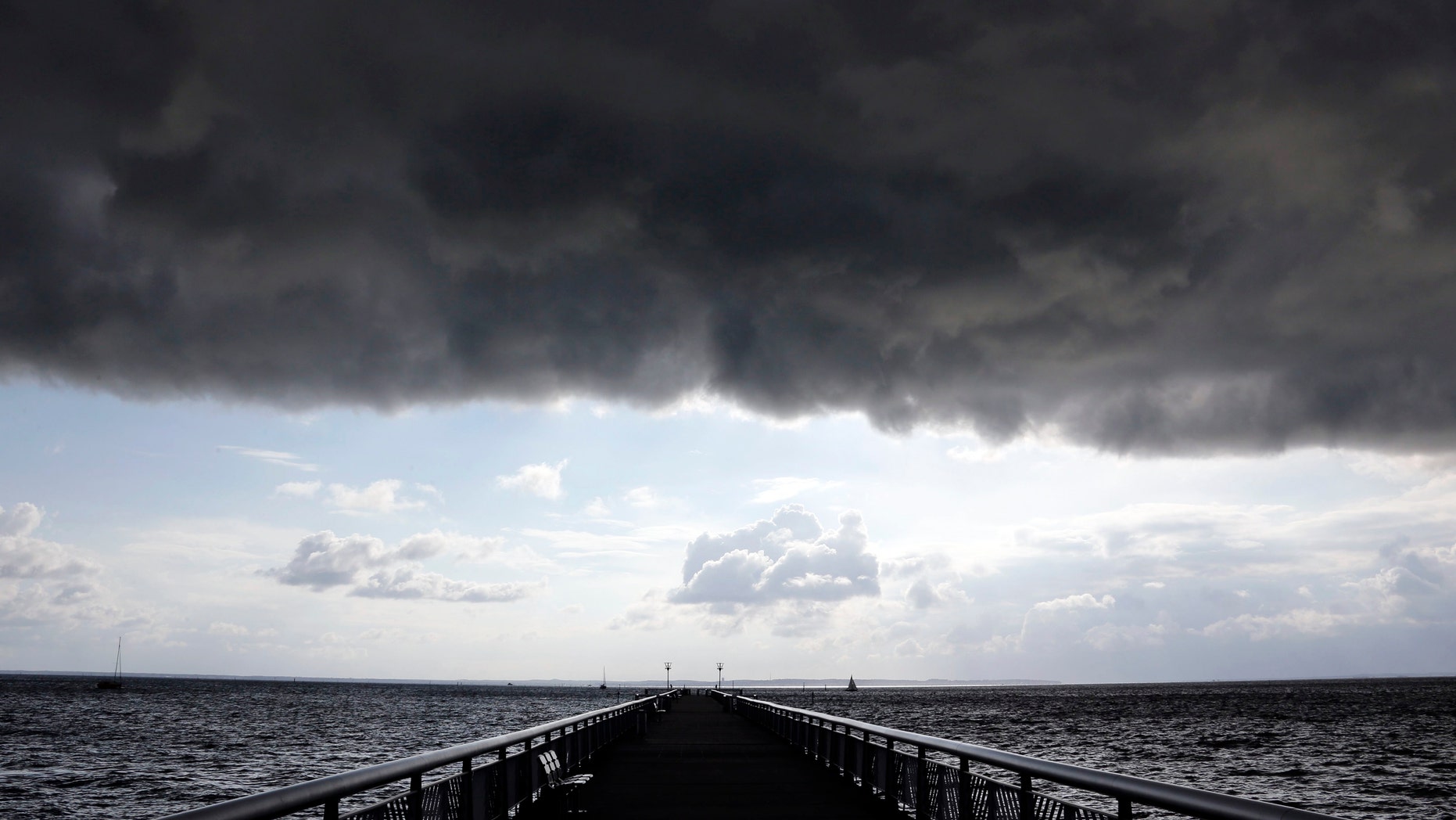 Dark clouds fill the Autumn sky over the jetty in Andernos, southwestern France, Nov. 4, 2014.