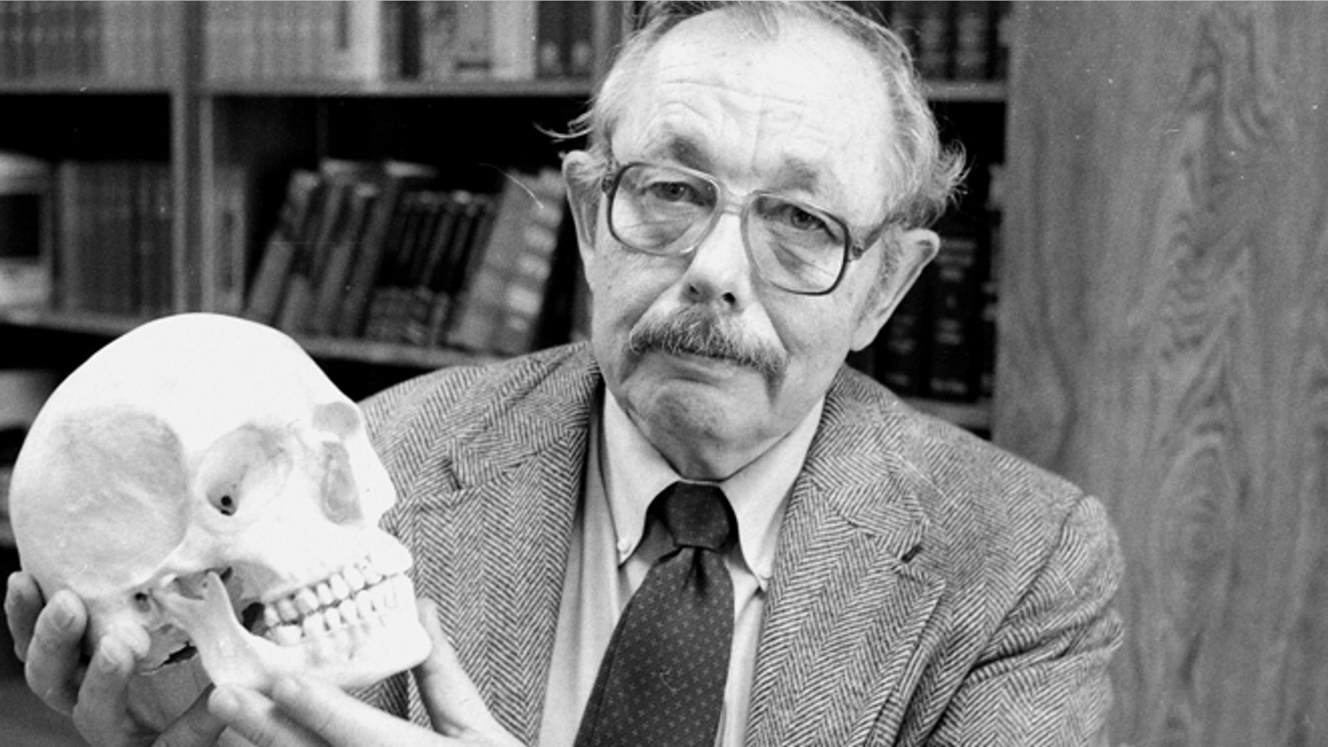 In a May 5, 1986 file photo, Dr. Clyde Snow holds a human skull in his office in Oklahoma City, Okla.