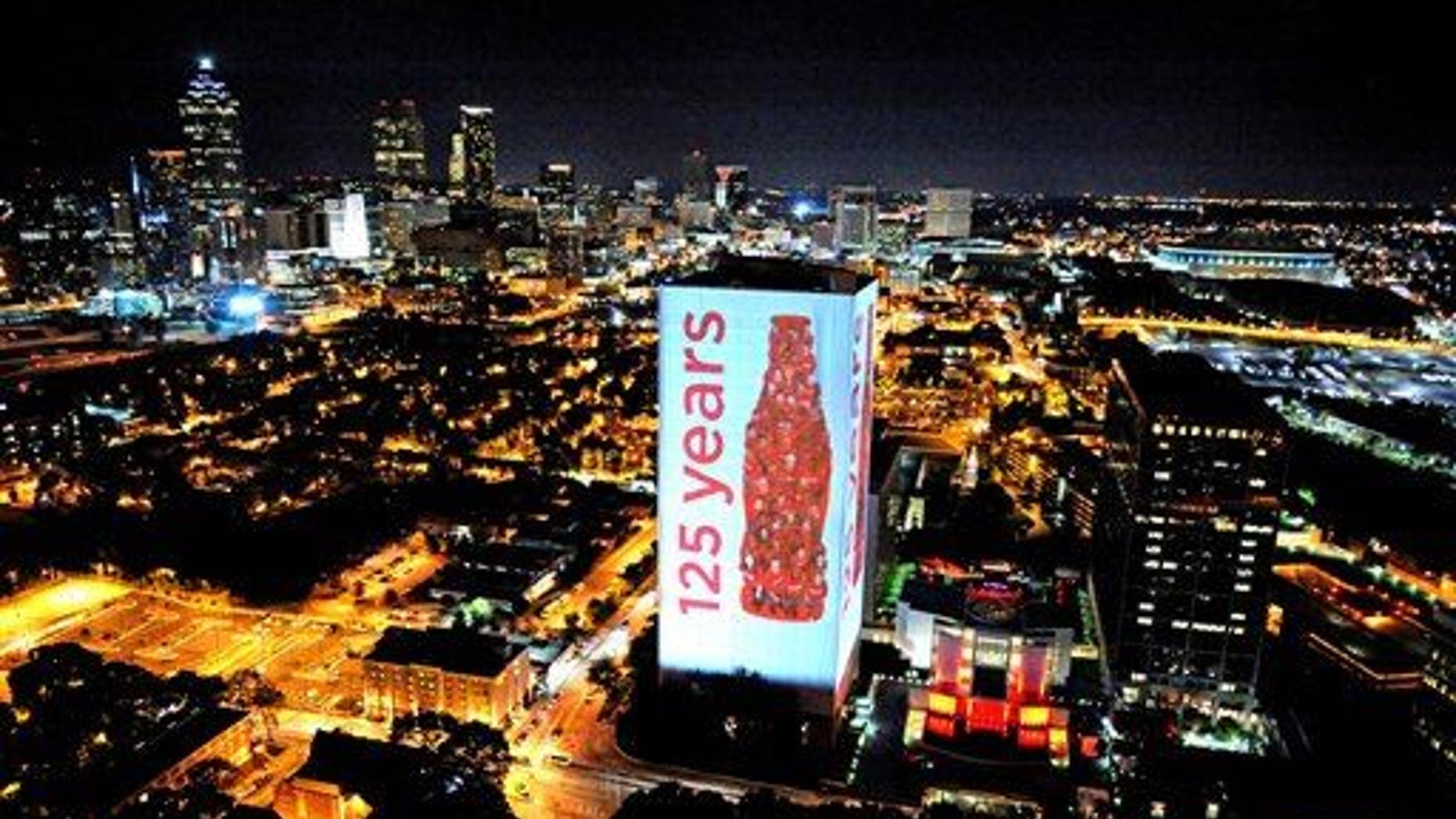 The headquarters building of The Coca-Cola Company is illuminated against the skyline of Atlanta.