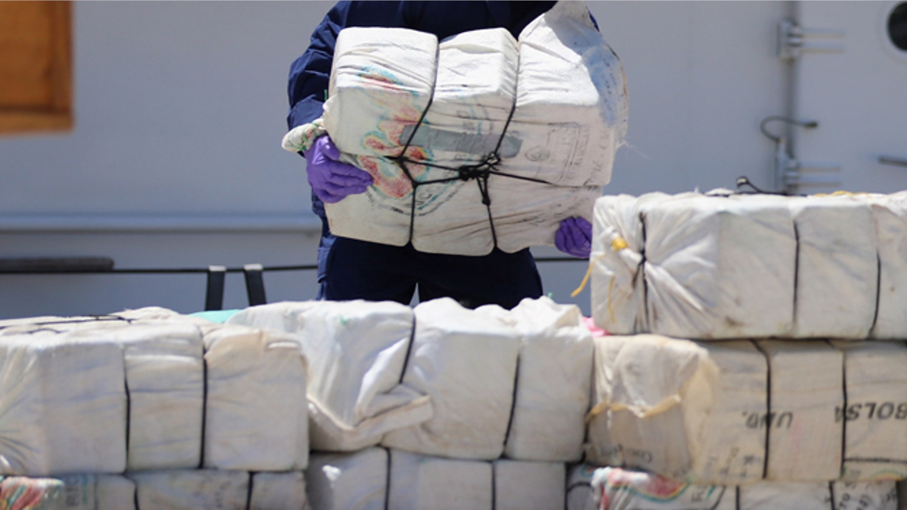 MIAMI, FL - APRIL 26: A crew member from the Coast Guard Cutter Bernard C. Webber piles up some of the 2,200 pounds of cocaine after it was seized during Operation Martillo, worth an estimated $27 million on April 26, 2013 in Miami, Florida. The cocaine was found while the crew was conducting a law enforcement patrol, where they located a 68-foot fishing vessel in the western Caribbean Sea, April 18, 2013. The crew of the Cutter Gallatin boarded the vessel, located 2,200 pounds of cocaine, and detained three suspected smugglers. (Photo by Joe Raedle/Getty Images)