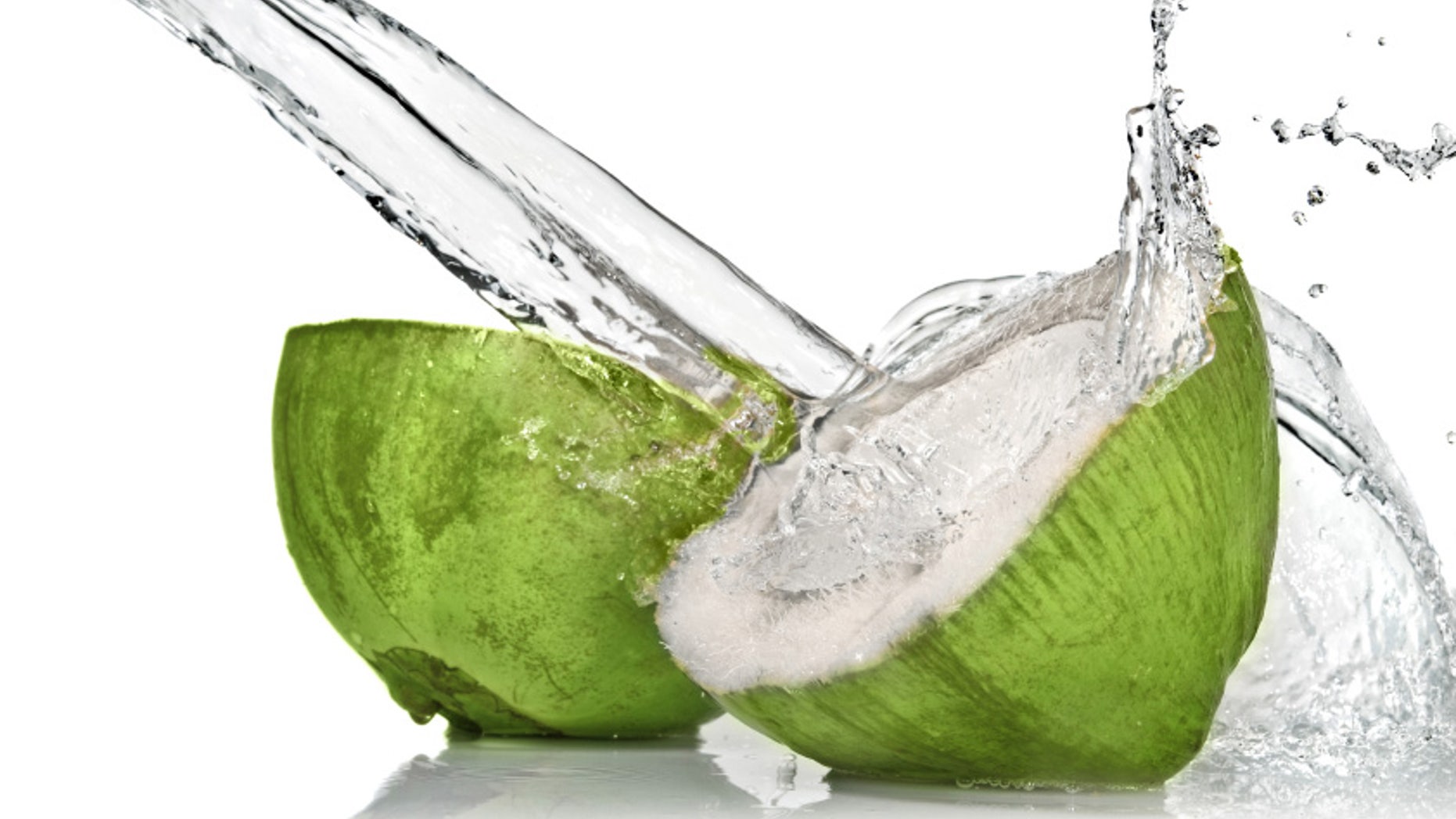 Green coconut with water splash isolated on white