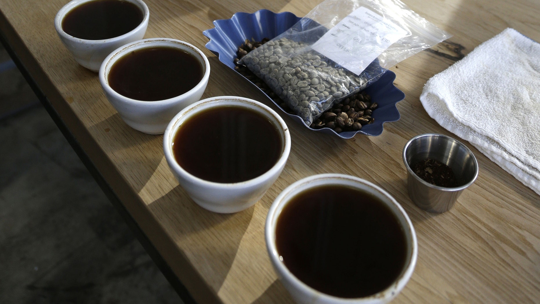 FILE - In this Jan. 3, 2013 file photo a row of brewed coffee is seen in Oakland, Calif. Scientists have woken up and smelled the coffee _ and analyzed its DNA. They found that what we love about coffee _ the caffeine _ is a genetic quirk, not related to the caffeine in chocolate or tea.Its an accident that has been frozen in place very likely by the influence of natural selection, says University of Buffalo evolutionary biologist Victor Albert. He and more than 60 other researchers from around the world mapped out genetic instruction book of java. Their results are published Thursday in the journal Science. (AP Photo/Eric Risberg, File)