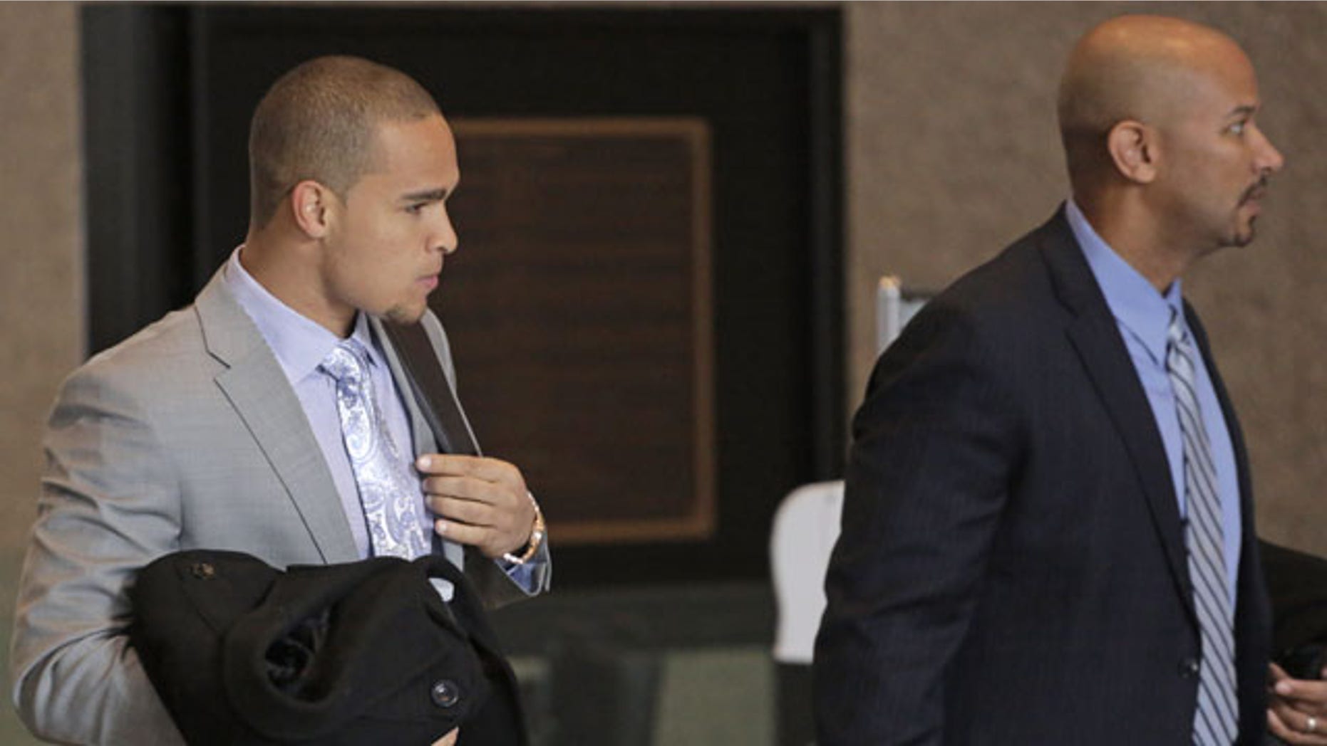 February 18, 2014: College Athletes Players Association designated president Ramogi Huma, right, and Northwestern University Wildcats' outgoing senior quarterback Kain Colter make their way to the beginning of three days of hearings before the National Labor Relations Board in Chicago. (AP)