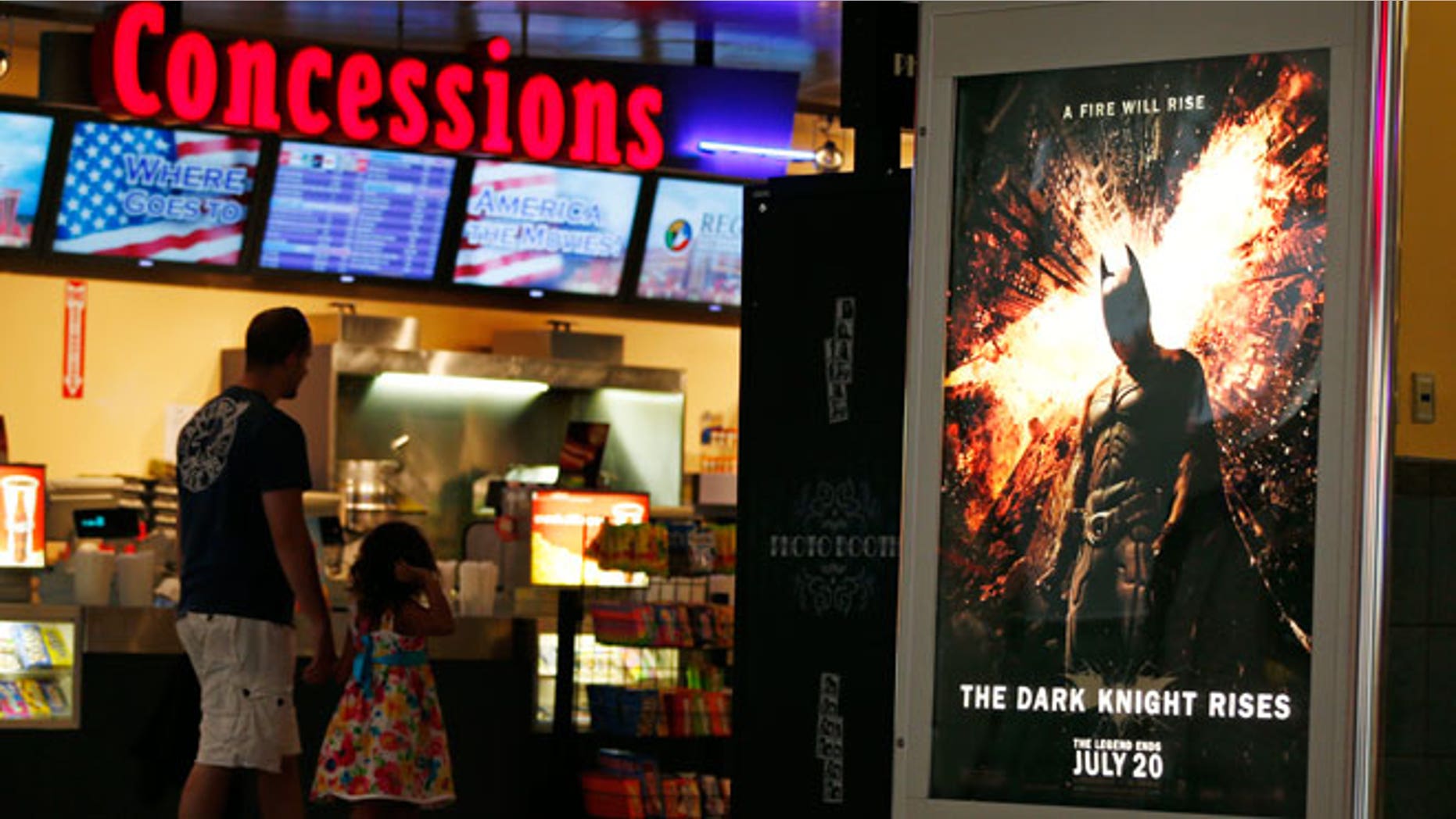 FILE - In this July 20, 2012 file photo, people walk past a "The Dark Knight Rises," at Regal Cinemas at Crossgates Mall in Albany, N.Y.