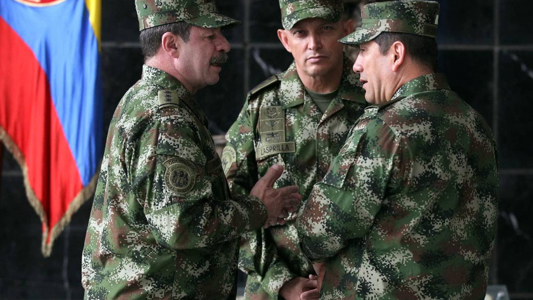 FILE - In this Feb. 18, 2014, file photo, the new Colombian armed forces commander Gen. Juan Pablo Rodriguez, right, talks to newly appointed chief of staff Gen. Javier Florez, left, and army commander Gen. Jaime Lasprilla, center, after a press conference where Defense Minister Juan Carlos Pinzon announced the firing of the fromer armed forces chief Gen. Leonardo Barrero in Bogota, Colombia. Gen. Rodriguez and Gen. Lasprilla are among dozens of senior Colombian army officers implicated in the killing of 3,000 civilians falsely claimed to be rebels a decade ago have risen through the ranks and are escaping punishment for their roles in one of the worst atrocities committed in Latin America, Human Rights Watch said Wednesday, June 23, 2015. (AP Photo/Fernando Vergara, File)
