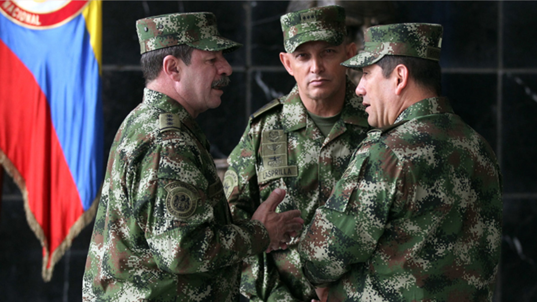 FILE - In this Feb. 18, 2014, file photo, the new Colombian armed forces commander Gen. Juan Pablo Rodríguez, right, talks to newly appointed chief of staff Gen. Javier Florez, left, and army commander Gen. Jaime Lasprilla, center, after a press conference where Defense Minister Juan Carlos Pinzon announced the firing of the fromer armed forces chief Gen. Leonardo Barrero in Bogotá, Colombia. Gen. Rodríguez and Gen. Lasprilla are among dozens of senior Colombian army officers implicated in the killing of 3,000 civilians falsely claimed to be rebels a decade ago have risen through the ranks and are escaping punishment for their roles in one of the worst atrocities committed in Latin America, Human Rights Watch said Wednesday, June 23, 2015. (AP Photo/Fernando Vergara, File)
