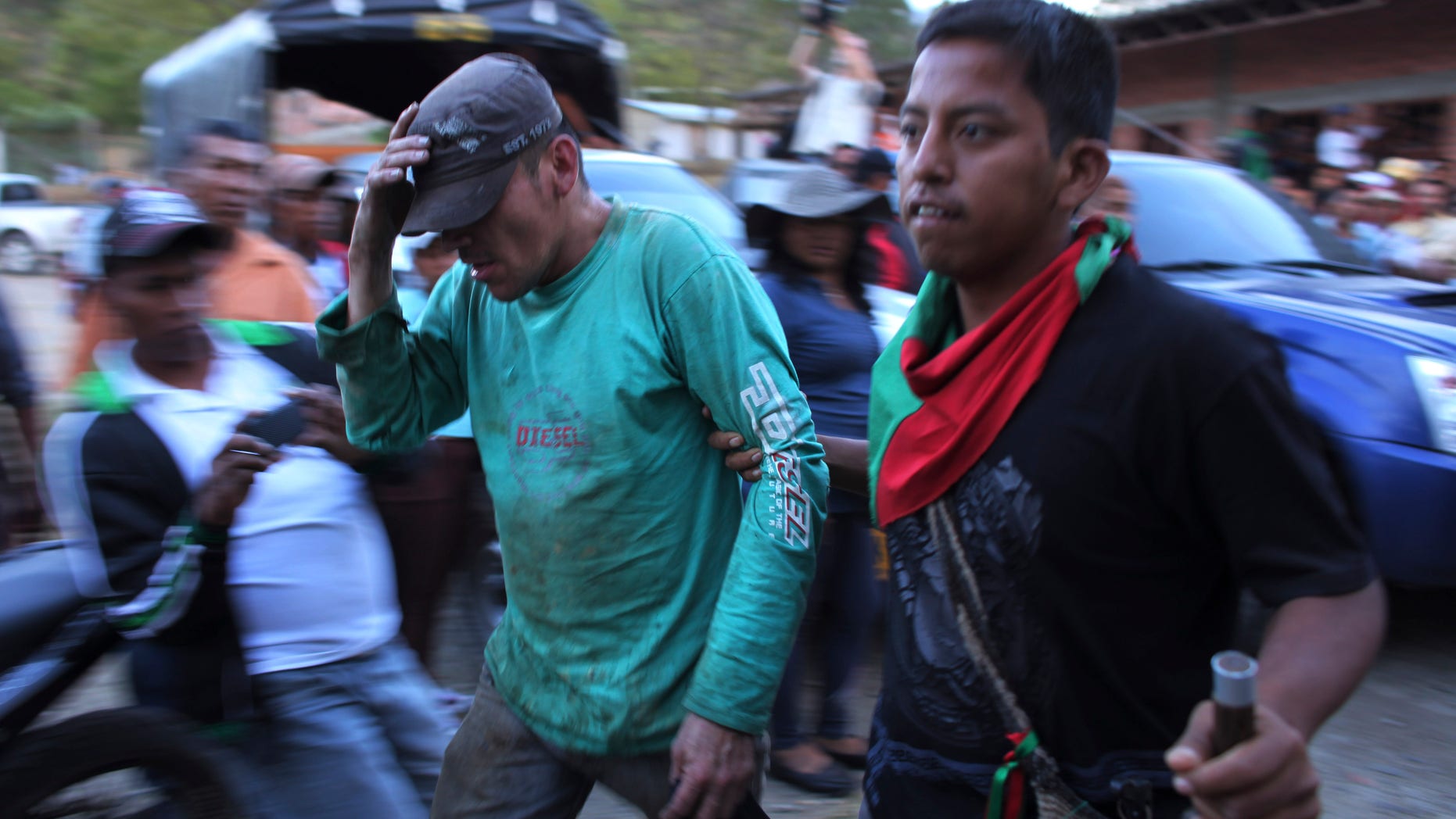 July 18, 2012: A member of the Nasa Indian Guard, right, escorts an alleged rebel in Toribio, Colombia.