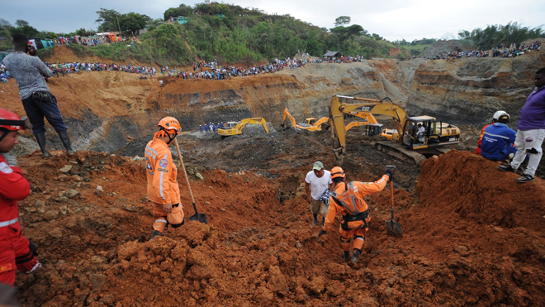 People watch for the search of survivors at a collapsed illegal gold mine in Santander de Quilichao, southern Colombia, Thursday, May 1, 2014. Colombian rescuers on Thursday hunted for more than a dozen people feared trapped beneath debris left by in the collapse of an illegal gold mine that killed at least three people, officials said. (AP Photo/Oswaldo Paez, El Pais)