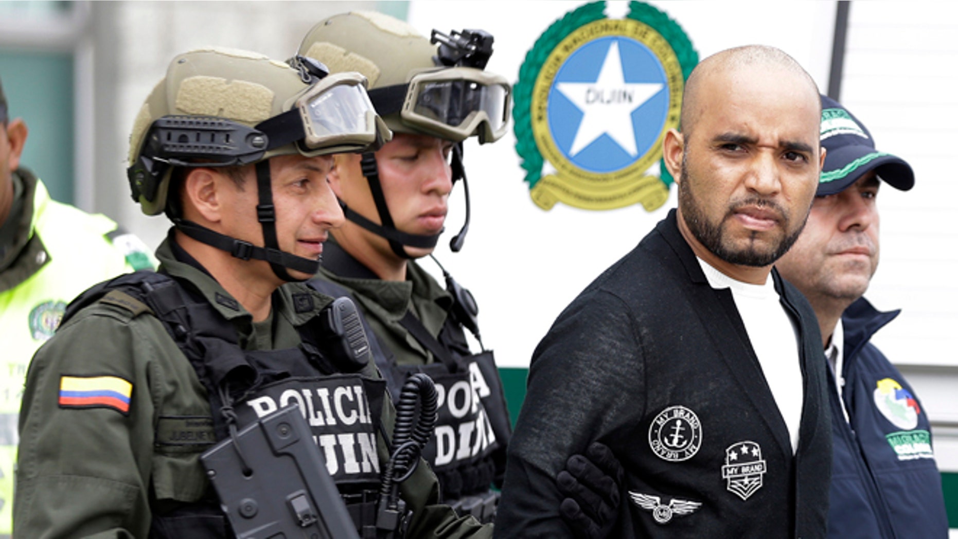 Alleged Peruvian drug trafficker Gerson Galvez, right, is escorted by police officers to a waiting Peruvian Air Force plane, in Bogota, Colombia, Sunday, May 1, 2016. Galvez who is one of Peru's most wanted criminals was captured by the Colombian police in Medellín on Saturday and was handed over to the Peruvian authorities. (AP Photo/Fernando Vergara)