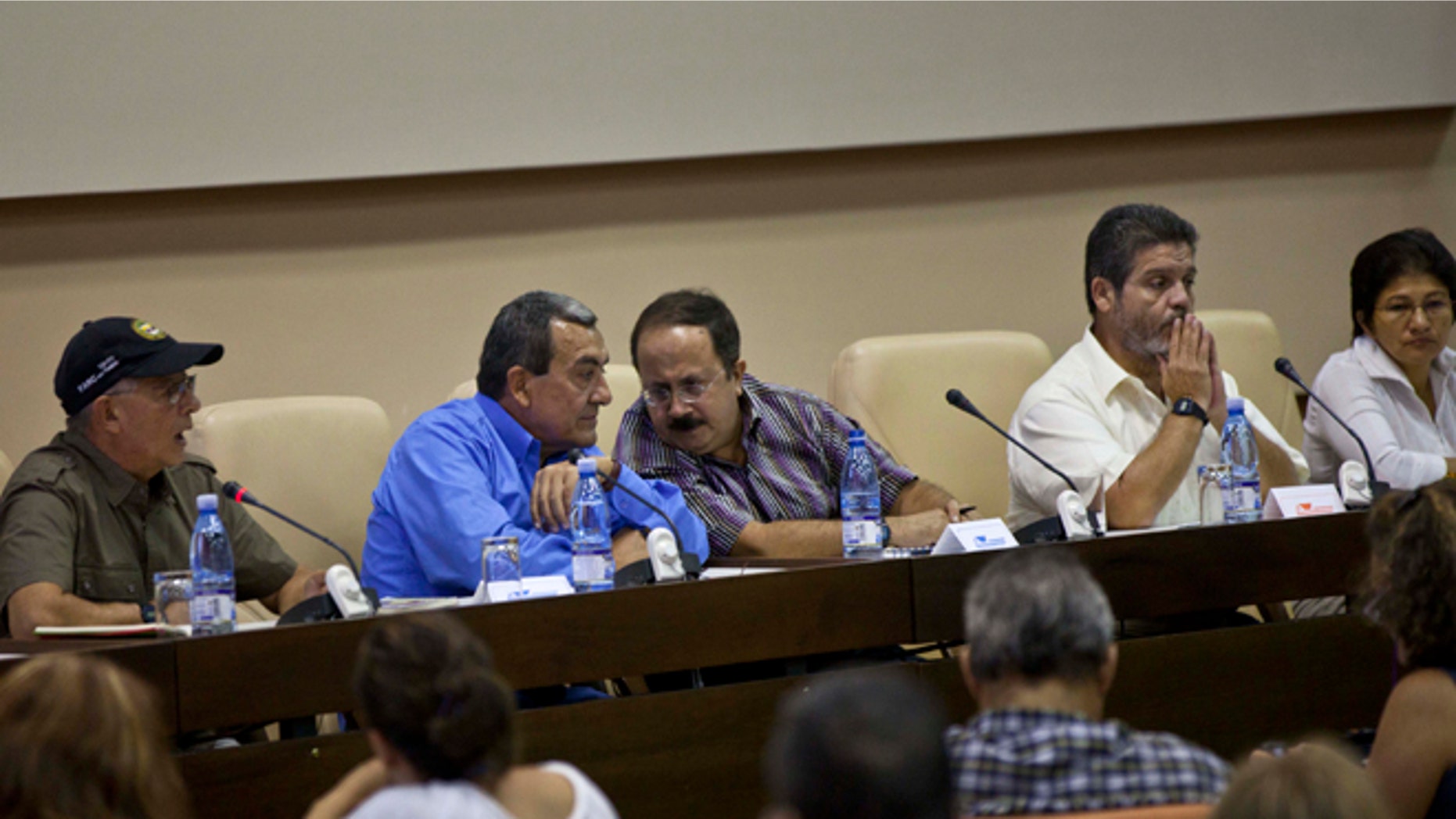 Mauricio Jaramillo, a spokesman and top leader of the Revolutionary Armed Forces of Colombia, or FARC, second from left, talks with FARC member Andres Paris during a press conference in Havana, Cuba, Thursday, Sept. 6, 2012. Colombia's main leftist rebel group announced two of its negotiators on Thursday for October peace talks in Norway, and said it hopes a high-ranking guerrilla imprisoned in the United States also can take part. (AP Photo/Ramon Espinosa)