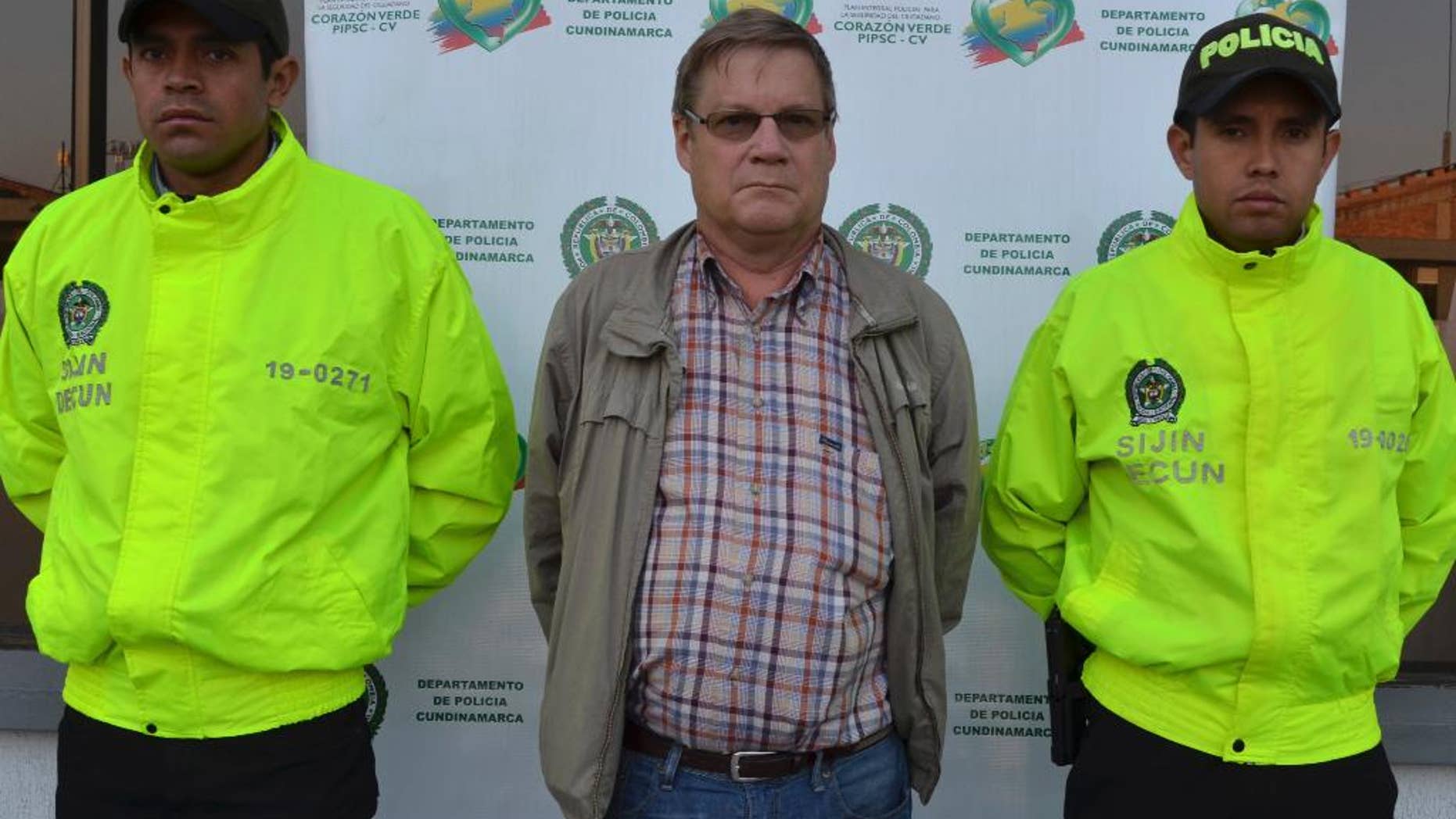 This photo released by Colombia's National Police shows American citizen Martin Stendal flanked by police officers at a police station in Bogota, Colombia, Thursday, Feb. 19, 2015. Police Col. Flavio Meza said that Stendal, a 59-year old native of Minnesota, surrendered Wednesday night to face an arrest warrant charging him with supporting terrorism and collaborating with the Revolutionary Armed Forces of Colombia rebel movement. Stendal says in a video posted online that he had been set up and that his trips into rebel territory to distribute Bibles and radios were only for ministering. (AP Photo/Colombia's National Police)