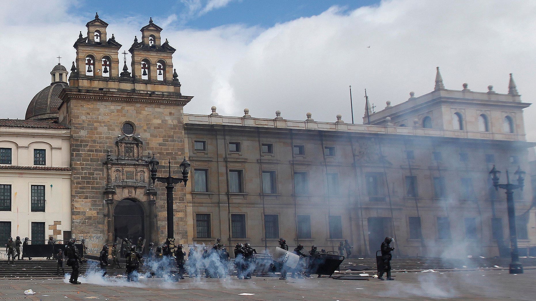 Riot police stand in the capital's main square during clashing with students in downtown Bogota, Colombia, Thursday, Aug. 29, 2013.