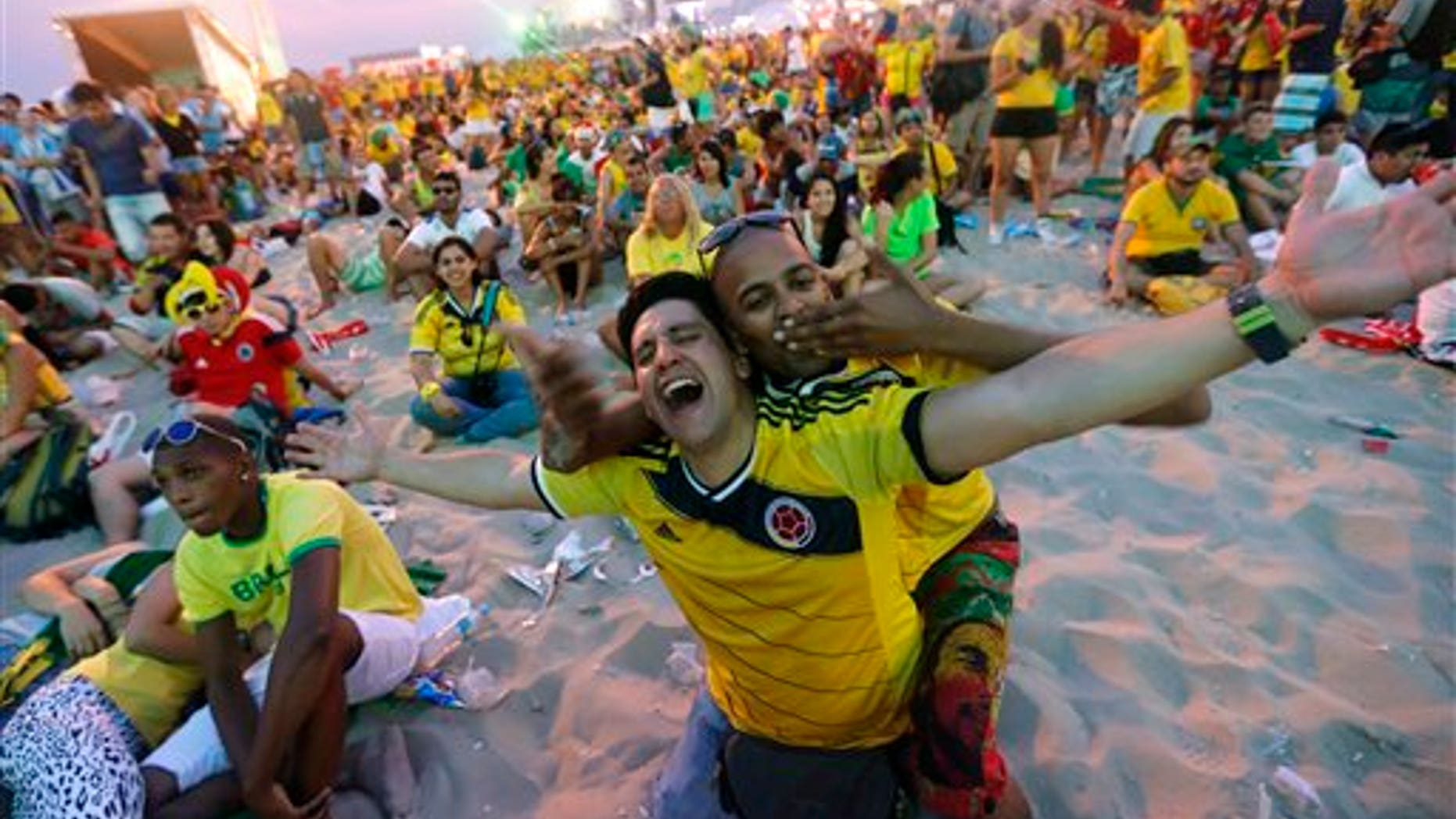 FILE - In this June 28, 2014, file photo, Colombia soccer fans celebrate a goal against Uruguay as they watch the World Cup round of 16 match inside the FIFA Fan Fest area on Copacabana beach in Rio de Janeiro, Brazil.
