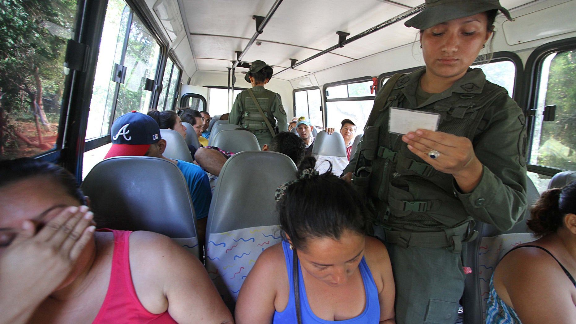 Venezuelan soldiers check the ID cards at a checkpoint along the border with Colombia.