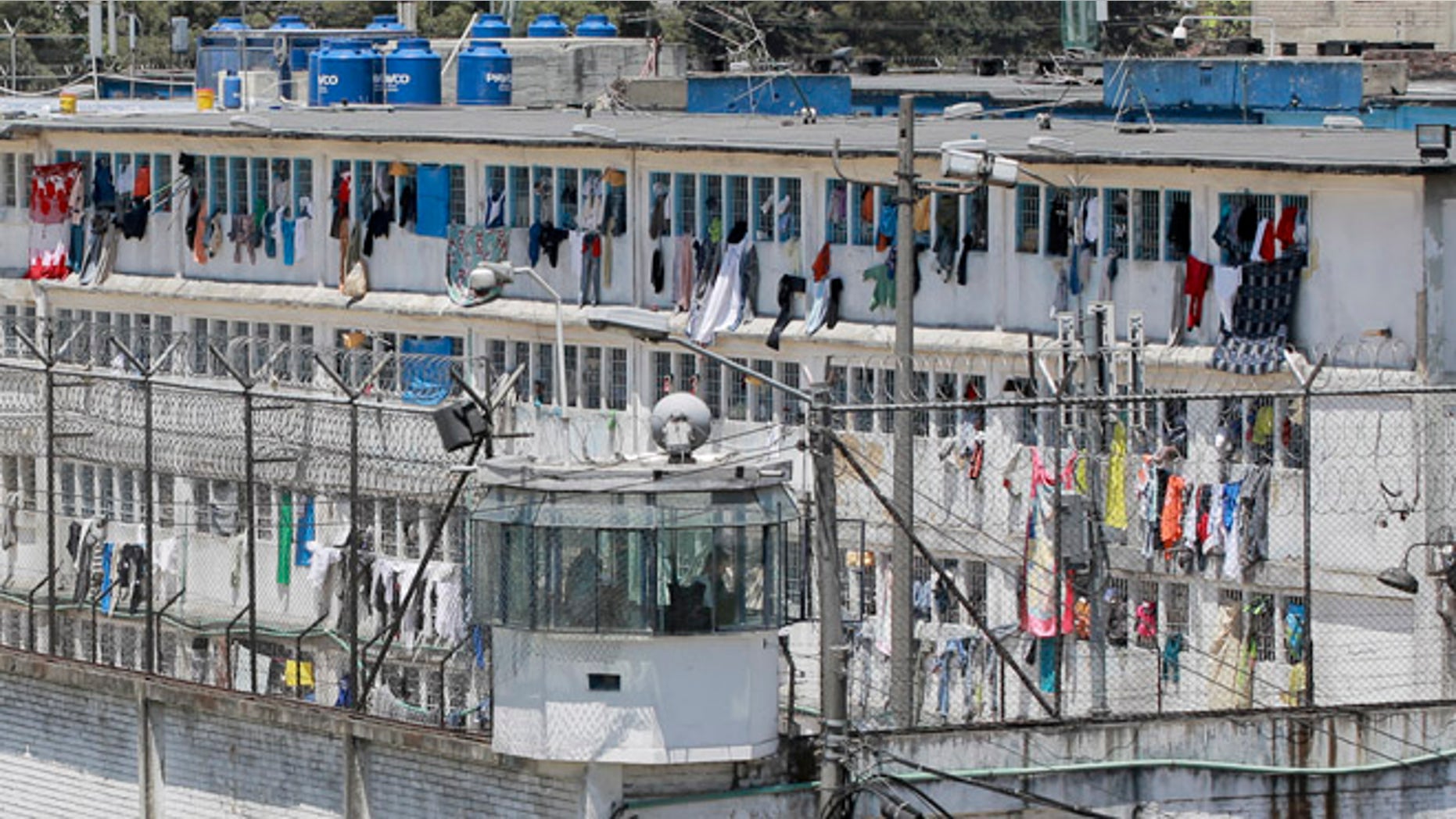 Corrections officers keep an eye out on prisoner's cells from a guard tower at La Modelo prison in Bogota, Colombia, Friday, Feb. 19, 2016. Prosecutors are investigating the alleged disappearance of as many as 100 people inside the prison more than 15 years ago based on years-old testimony from demobilized paramilitary fighters. Authorities have not undertaken any excavation efforts nor have family members of alleged victims come forward publicly. (AP Photo/Ricardo Mazalan)