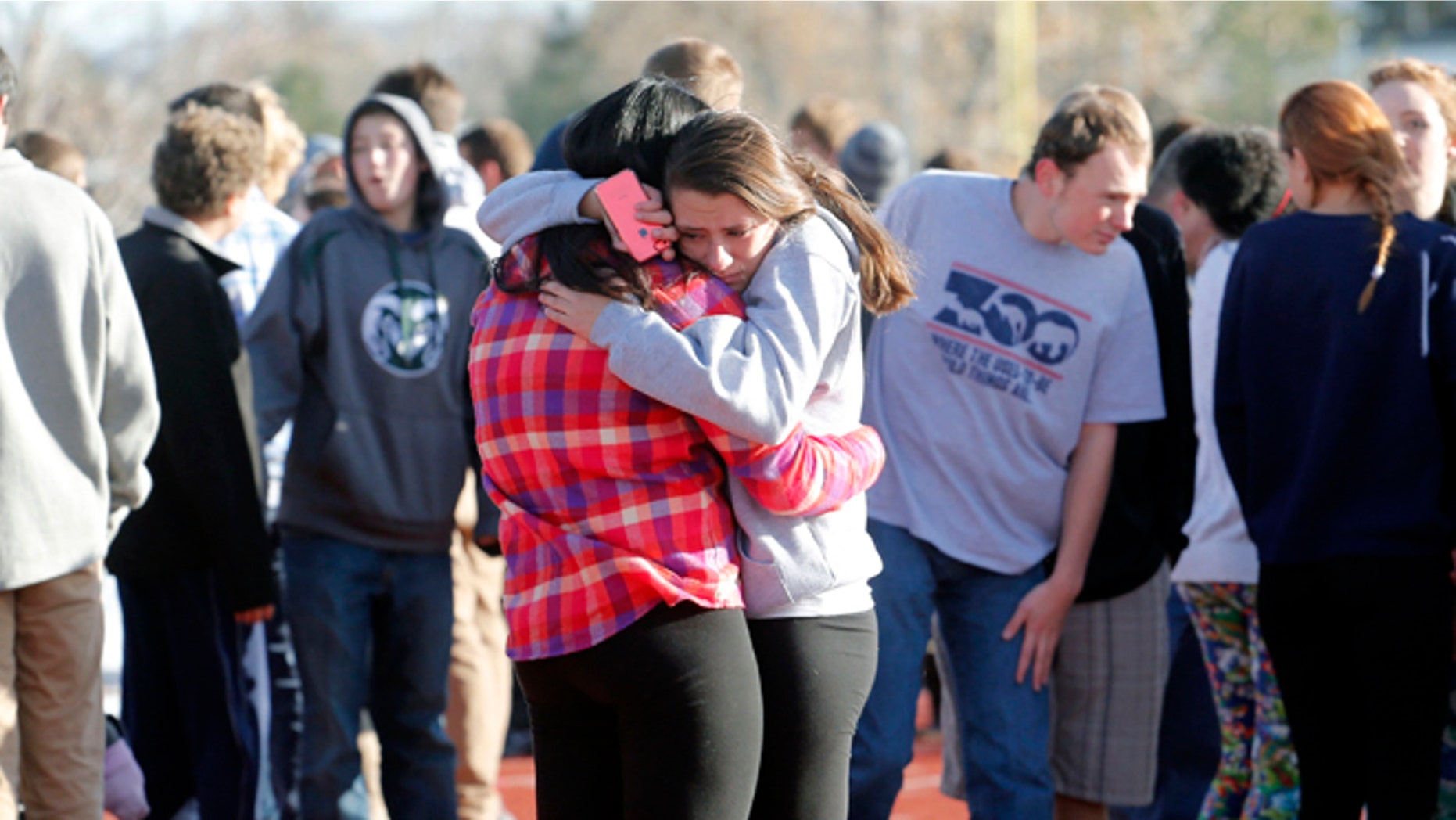 Students comfort each other at Arapahoe High School in Centennial, Colo., on Friday, Dec. 13, 2013, where a student shot at least one other student at a Colorado high school Friday before he apparently killed himself, authorities said. The shooter entered Arapahoe High School in a Denver suburb armed with a shotgun and looking for a teacher he identified by name, said Arapahoe County Sheriff Grayson Robinson. (AP Photo/Ed Andrieski)