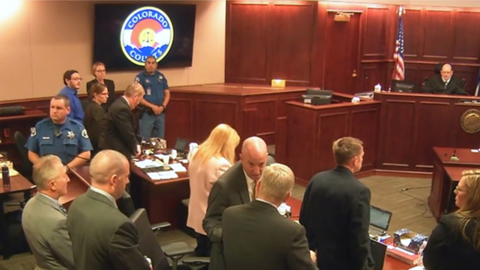 July 10, 2015: In this image taken from Colorado Judicial Department video, Colorado theater shooter James Holmes, upper left in blue shirt, joins others in standing as the jury, not pictured, is brought into the courtroom, during Holmes' trial in Centennial, Colo. (Colorado Judicial Department via AP, Pool)