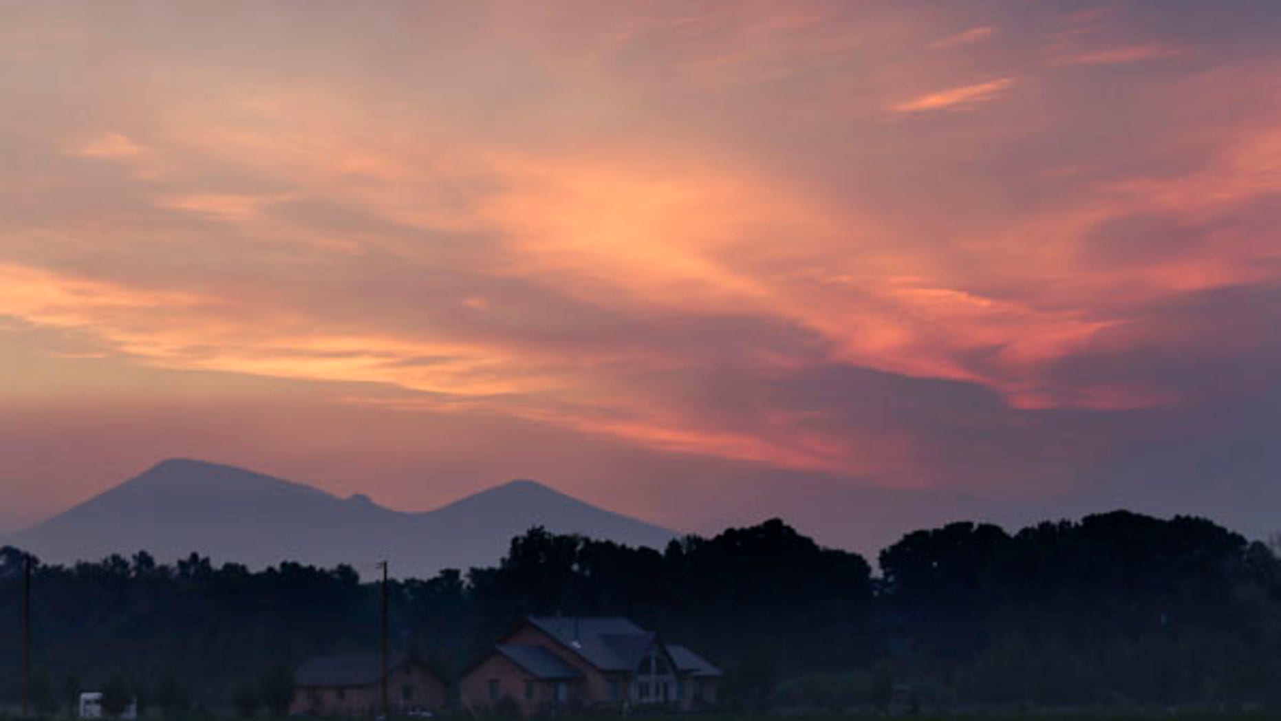 June 22, 2013: Smoke fills the sky as dawn breaks over a mountain range near South Fork, Colo. Fire crews with tankers and hoses stood guard Friday night as a massive and fast-burning wildfire threatened a popular mountain tourist enclave in southwestern Colorado, forcing the evacuation of more than 400 people.