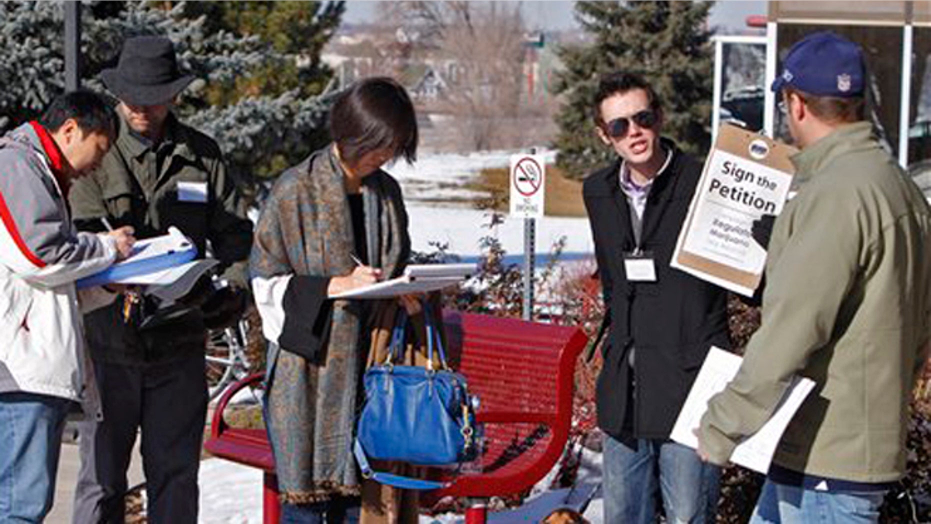FILE: Dec. 8, 2011: Volunteers collect signatures on a petition to legalize marijuana in Colorado.