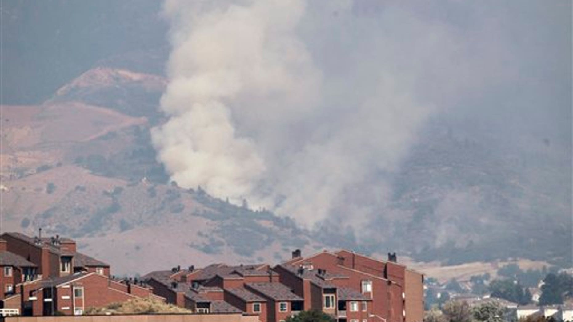 June 27, 2012: A plume of smoke rises behind homes on the Waldo Canyon wildfire west of Colorado Springs, Colo.