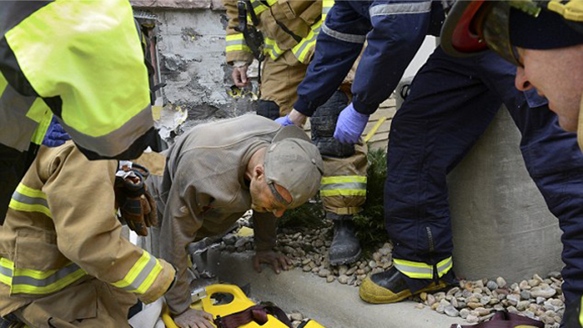 November 11, 2014: A man trapped in a wall at the rear of a Marshalls store in Longmont, Colo., crawls out of a hole and onto a backboard. Longmont Police Sgt. Matt Cage said Paul Felyk, 35, was taken to Longmont United Hospital after falling about 20 feet inside the walls and becoming trapped. (AP Photo/The Daily Times Call, Lewis Geyer)