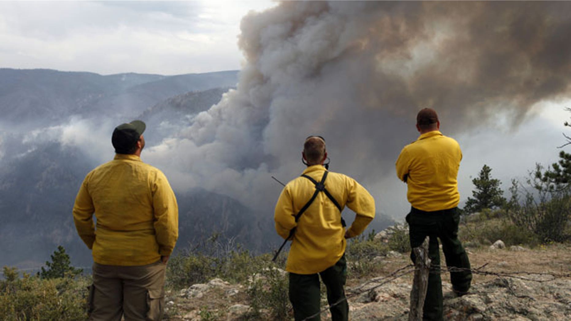June 14, 2012: Firefighters watch as flames leap hundreds of feet in the air as the High Park wildfire fire explodes on the south side of Poudre Canyon west of Fort Collins, Colo.