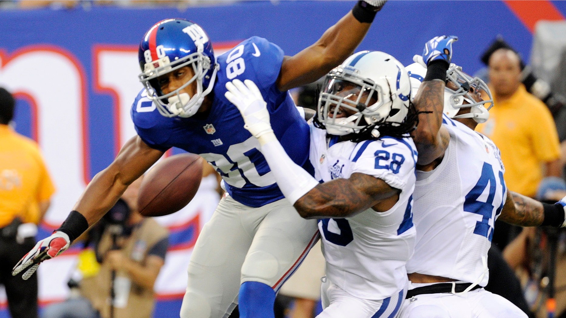Indianapolis Colts cornerback Greg Toler (28) and Antoine Bethea (41) defend against New York Giants wide receiver Victor Cruz (80) during the first half of an NFL preseason football game on Sunday, Aug. 18, 2013, in East Rutherford, N.J. Pass interference was called on the play. (AP Photo/Bill Kostroun)