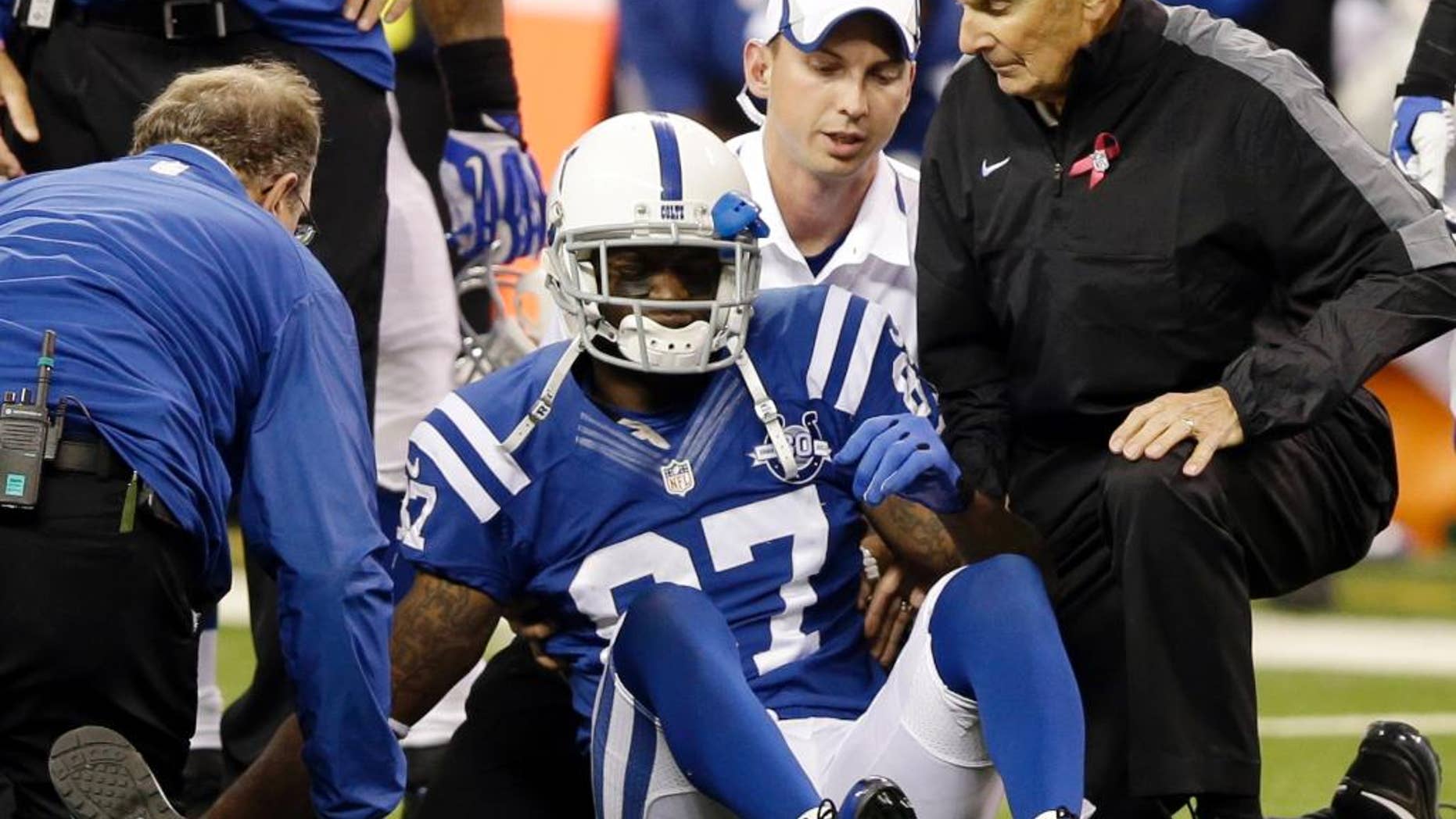 FILE - In this Oct. 20, 2013, file photo, Indianapolis Colts wide receiver Reggie Wayne (87) talks to trainers after he injured his knee during the second half of an NFL football game against the Denver Broncos in Indianapolis. The last time Wayne played in a regular-season game, he was limping off the field against Denver. On Sunday night, he'll return against those same Broncos and his old friend Peyton Manning. For Wayne, it's the culmination of a 9 1/2-month recovery from a torn ACL in his right knee. (AP Photo/Michael Conroy, File)