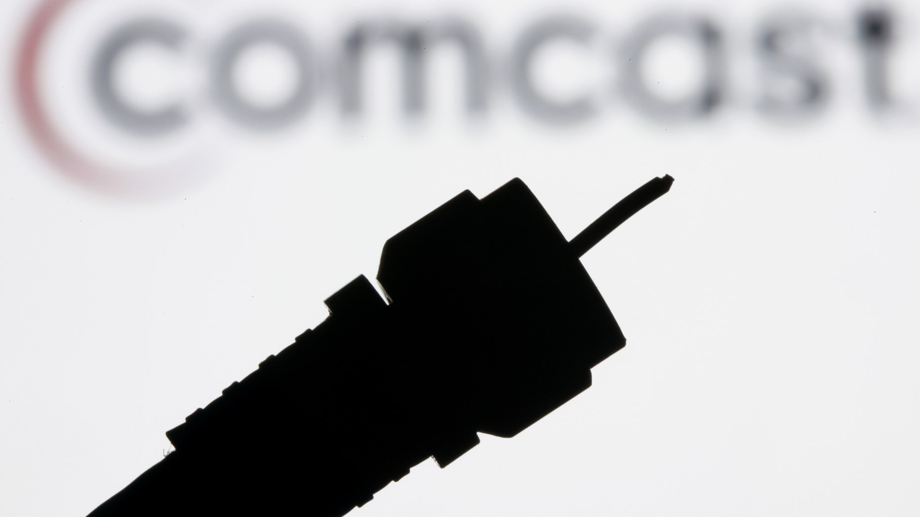 FILE - In this July 30, 2008 file photo illustration, a silhouetted coaxial cable is photographed with the Comcast Corp. logo in the background in Philadelphia.Comcast Corp. announced Thursday that it is buying Time Warner Cable Inc. for $45.2 billion in stock. The deal combines two of the nation's top pay TV and Internet service companies and makes Comcast, which also owns NBCUniversal, a dominant force in both creating and delivering entertainment to U.S. homes. (AP Photo/Matt Rourke, file)
