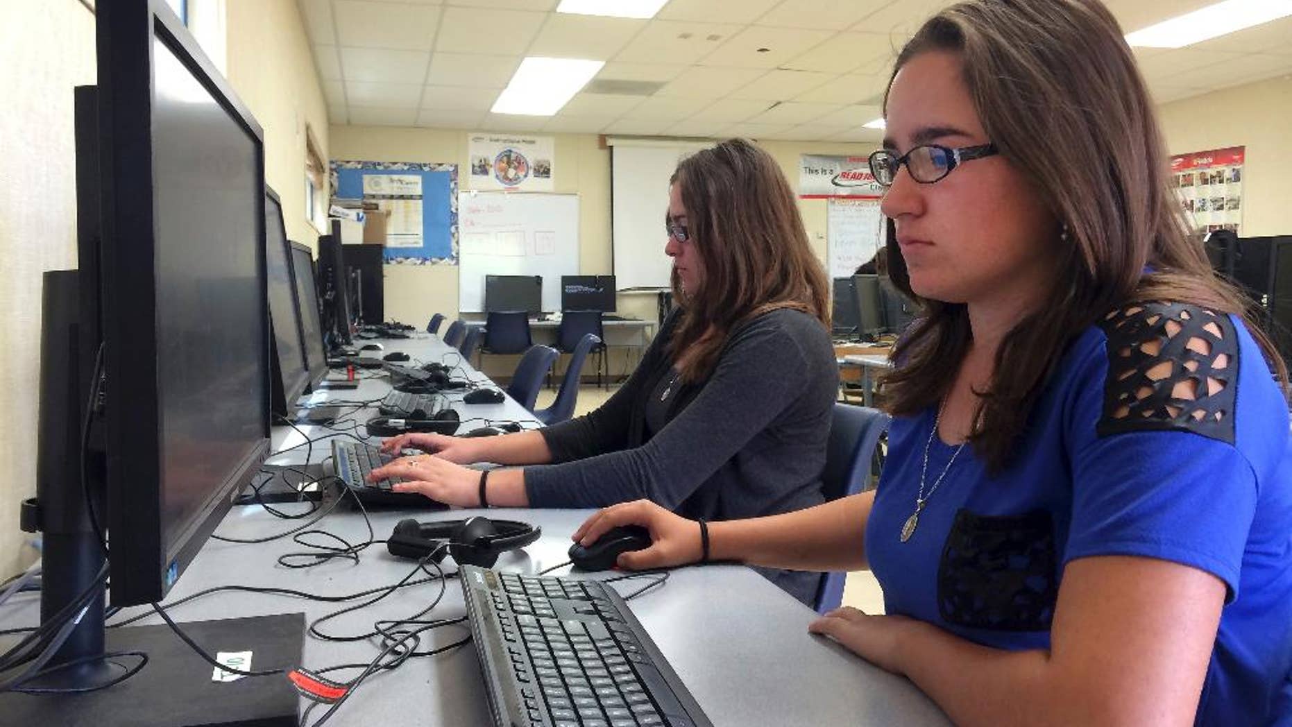 In this April 30, 2015 photo, Leticia Fonseca, 16, left, and her twin sister, Sylvia Fonseca, right, work in the computer lab at Cuyama Valley High School after taking the new Common Core-aligned standardized tests, in New Cuyama, Calif. While the Common Core education standards provoked political backlash and testing boycotts around the country this year, California, the state that educates more public school children than any other, was conspicuously absent from the debate. Gov. Jerry Brown and California’s elected K-12 schools chief are united in their support of the embattled benchmarks. The heads of the state’s teachers’ unions, universities and business groups are on board, too. More than one-quarter of the 12 million students who were supposed to take new online tests linked to the standards this spring were Californians, but the technical glitches and parent-led opt-out campaigns that roiled the exams’ rollout elsewhere did not surface widely here. (AP Photo/Christine Armario)