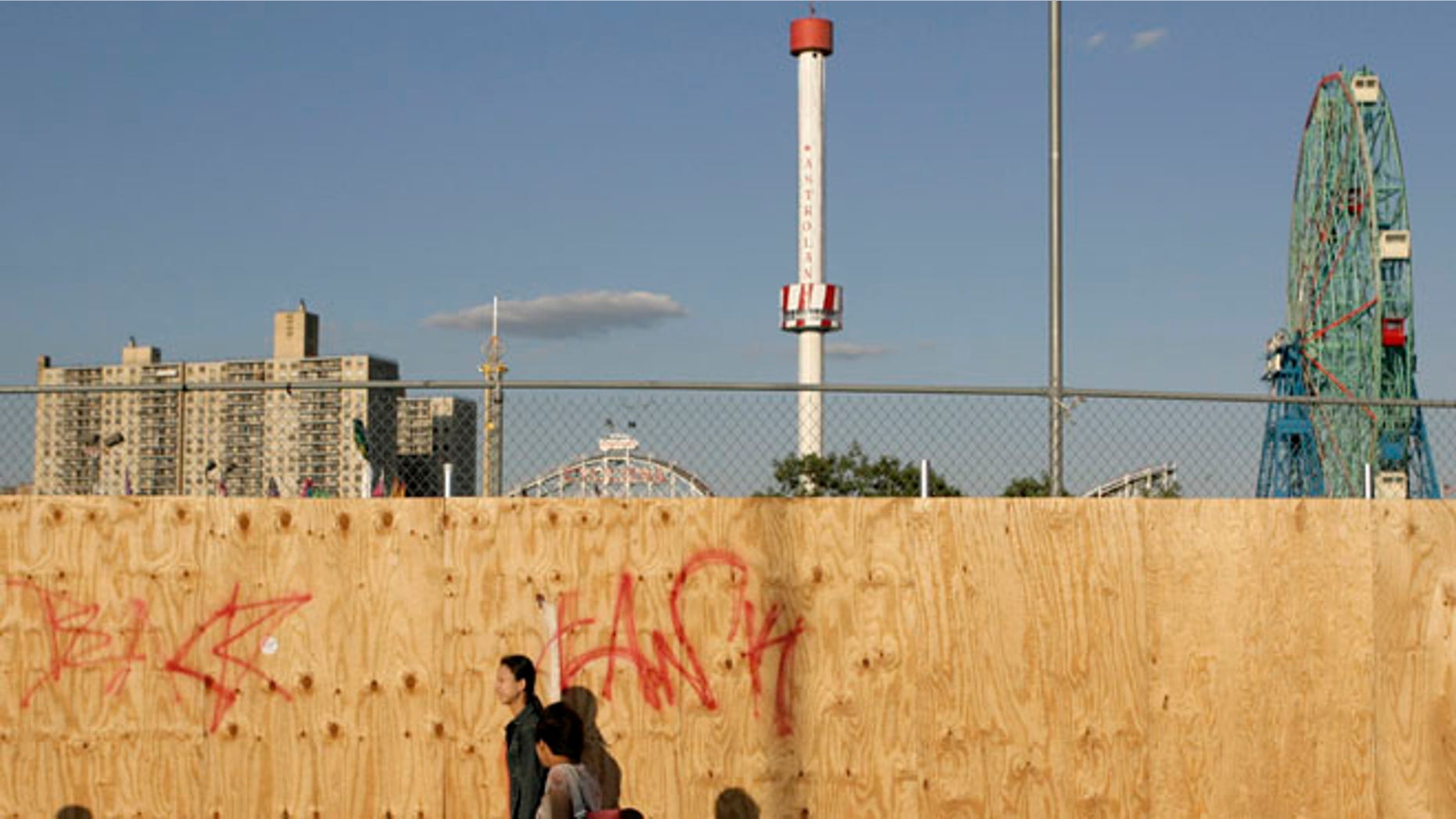 June 6, 2007: In this file photo, pedestrians walk past a boarded up section of the Coney Island amusement district in the Brooklyn borough of New York with the Astrotower rising in the background.
