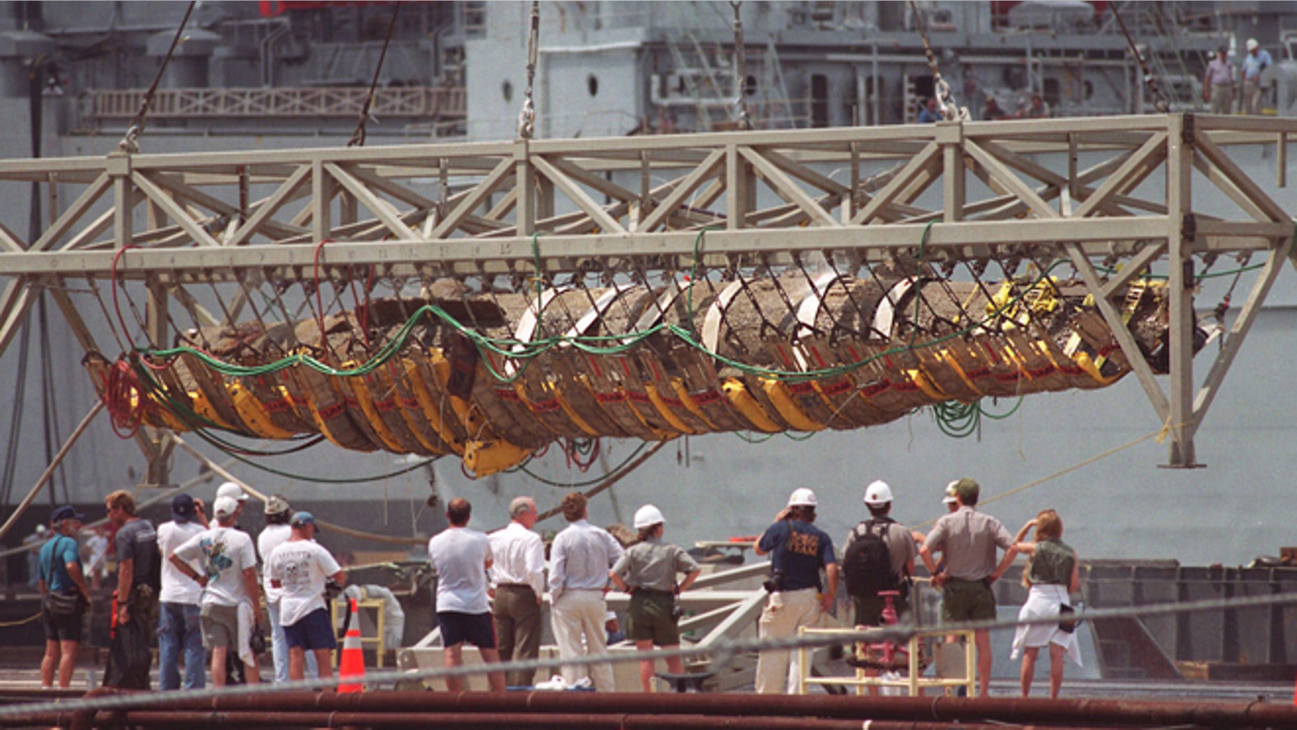 The Confederate submarine H.L. Hunley is raised from a barge by a crane at the former Charleston Naval Base in North Charleston, S.C., in this Aug. 8, 2000, file photo.