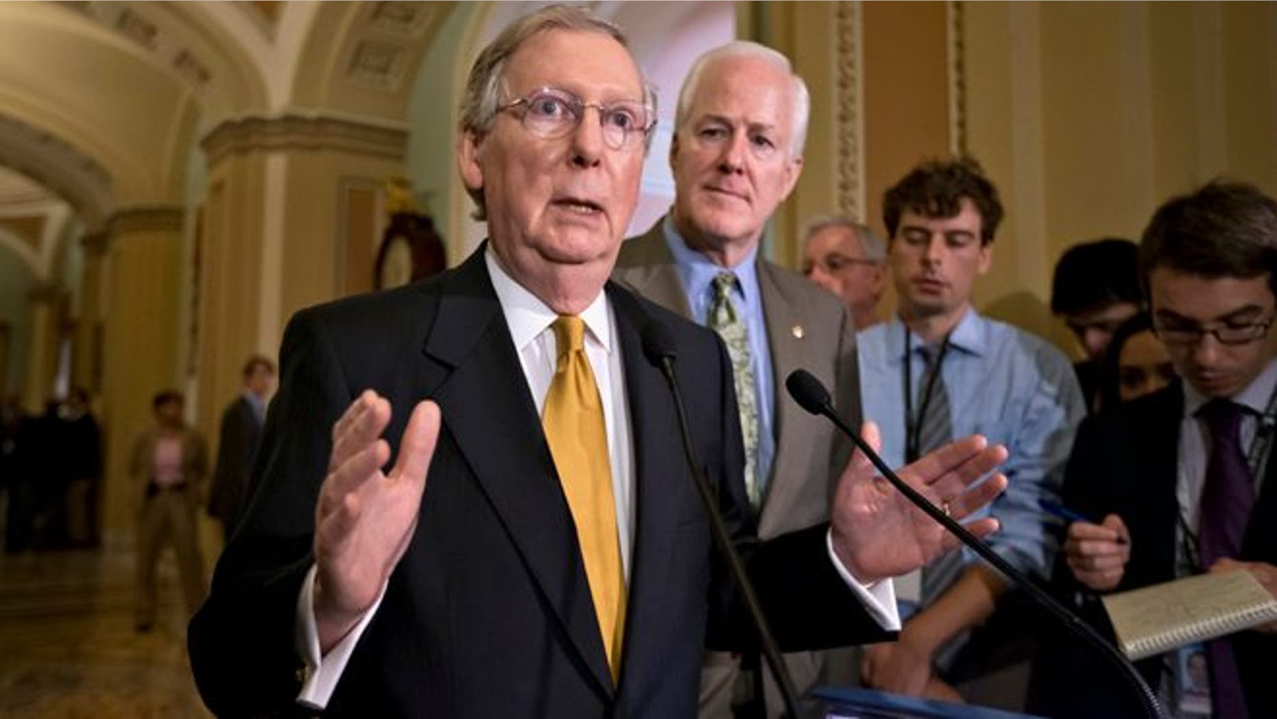 Senate Minority Leader Mitch McConnell of Ky., left, accompanied by Senate Minority Whip John Cornyn of Texas, gestures as he speaks with reporters on immigration, intelligence leaks and other issues following a Republican strategy session on Capitol Hill in Washington, Tuesday, June 11, 2013. (AP Photo/J. Scott Applewhite)