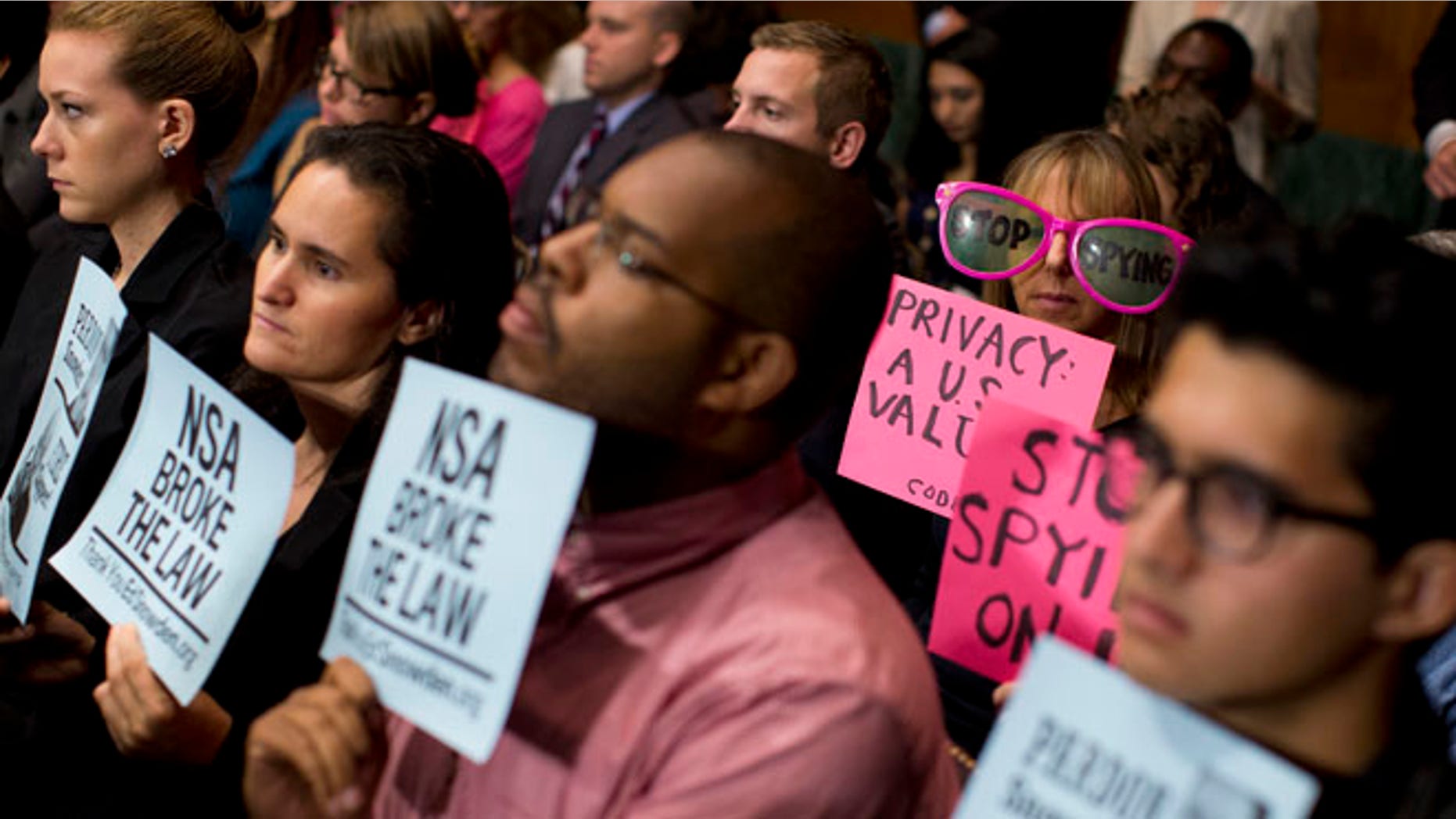 FILE: Oct. 2, 2013: Protestors hold signs, and CodePink founder Medea Benjamin wears oversized sunglasses during a Senate hearing on the Foreign Intelligence Surveillance Act.
