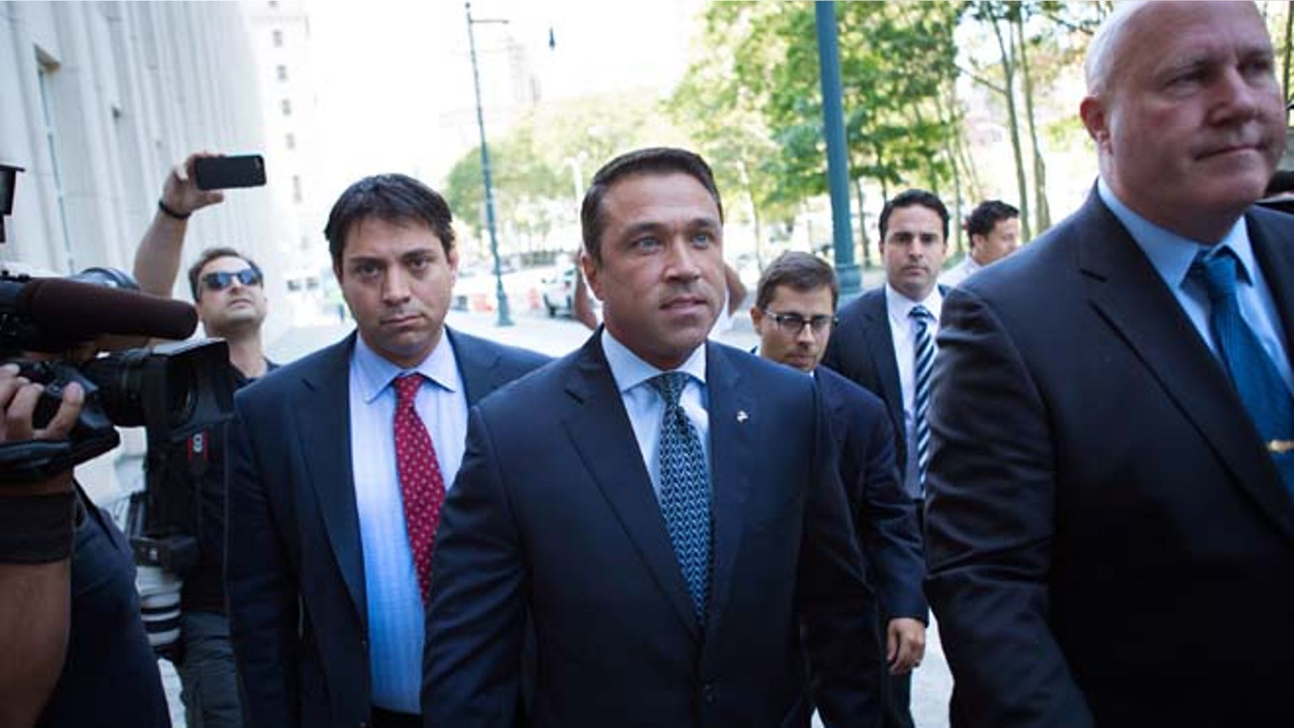 Former U.S. Rep. Michael Grimm, center, arrives ahead of his sentencing at federal court Friday, July 17, 2015, in the Brooklyn borough of New York. Grimm pleaded guilty late last year to aiding in filing a false tax return, a charge that stemmed from an investigation into the Staten Island Republican's campaign financing. (AP Photo/Kevin Hagen)
