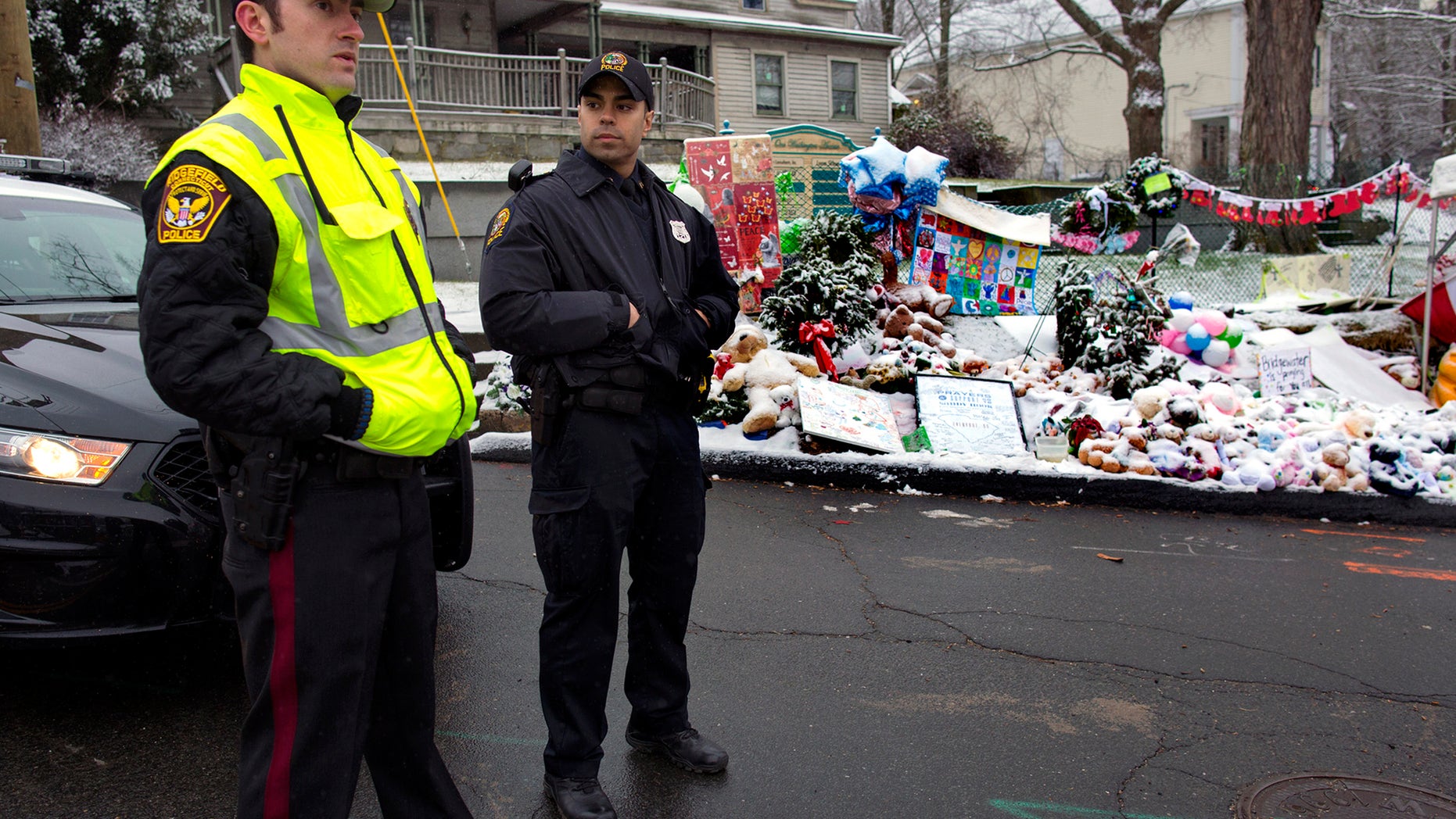 Dec. 25, 2012: From left, Town of Ridgefield, Conn., Det. Durling, and Town of Greenwich, Conn., Officer Rivera stand near a memorial in Newtown, Conn. Regional police agencies arrived in Newtown to relieve the local police force for the Christmas holiday.